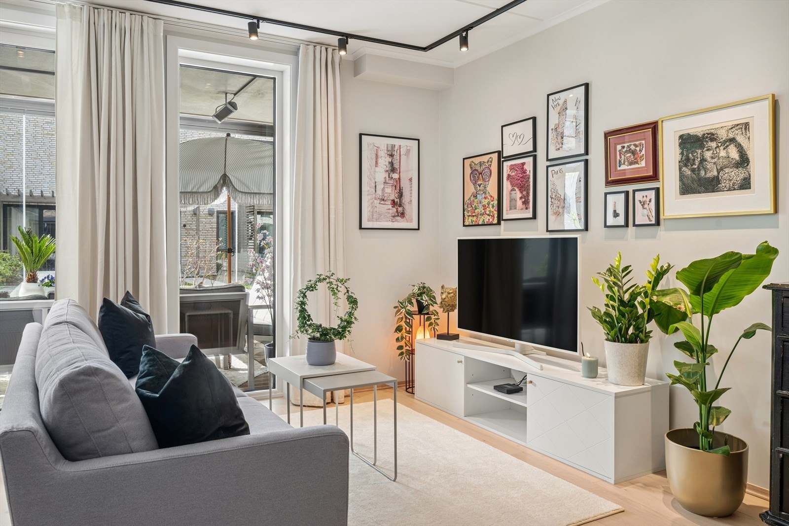 Rommet har god plass til sofamøblement, og i taket er det montert en stilren sort lysskinne. Galleribilde