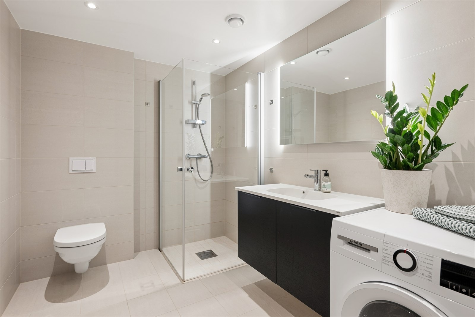 Badet er utført med delikate og tidløse fliser på både gulv og vegger, og er innredet med moderne baderomsmøbler. Galleribilde