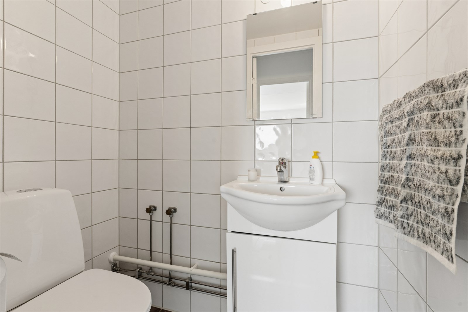 Leiligheten har et praktisk, separat toalettrom med fliser på gulv og vegger. Galleribilde