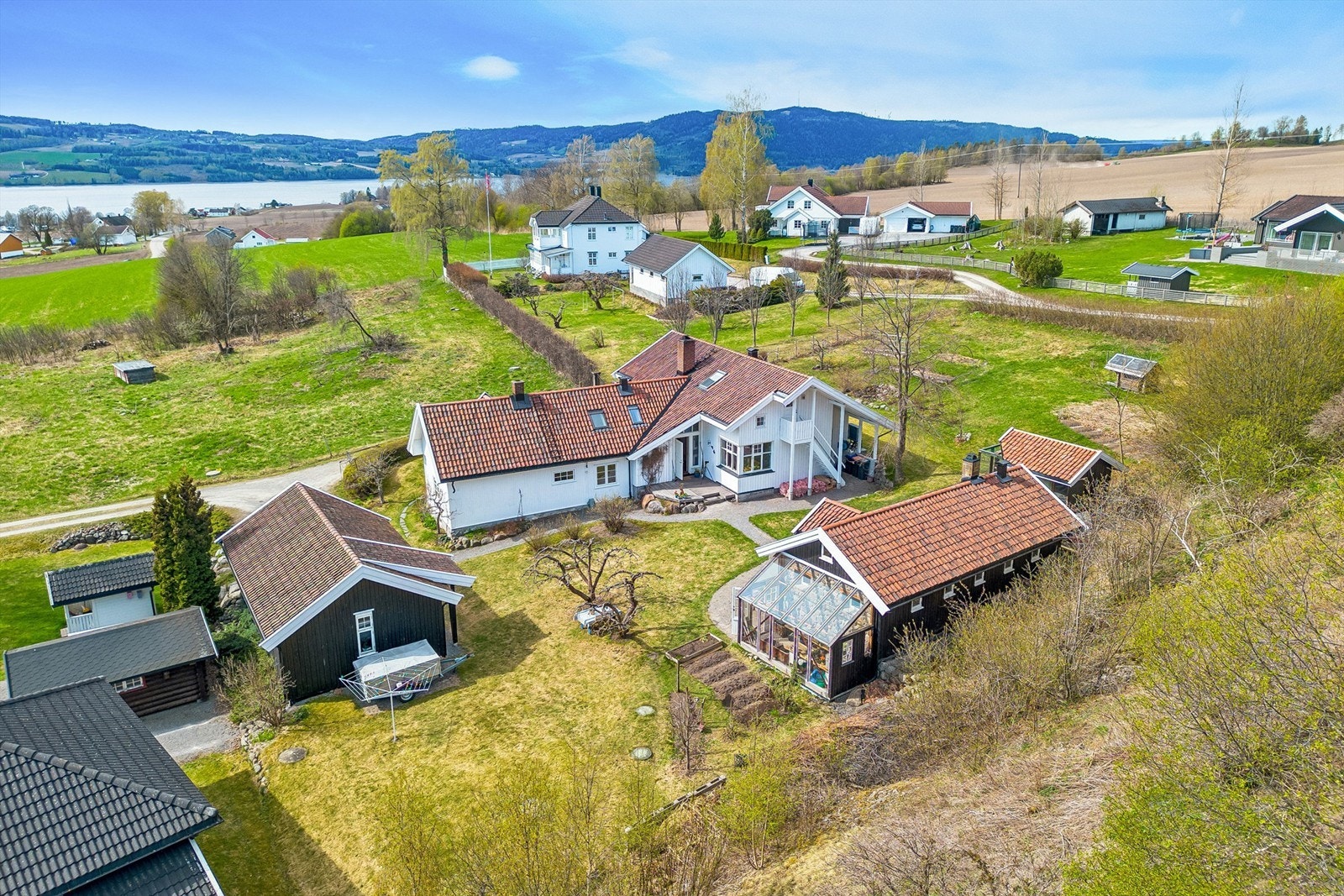 Tunet består av hovedhus, uthus, dobbel carport med bod og eget hønsehus, og gir en variert og fleksibel eiendom med mange bruksområder. Galleribilde