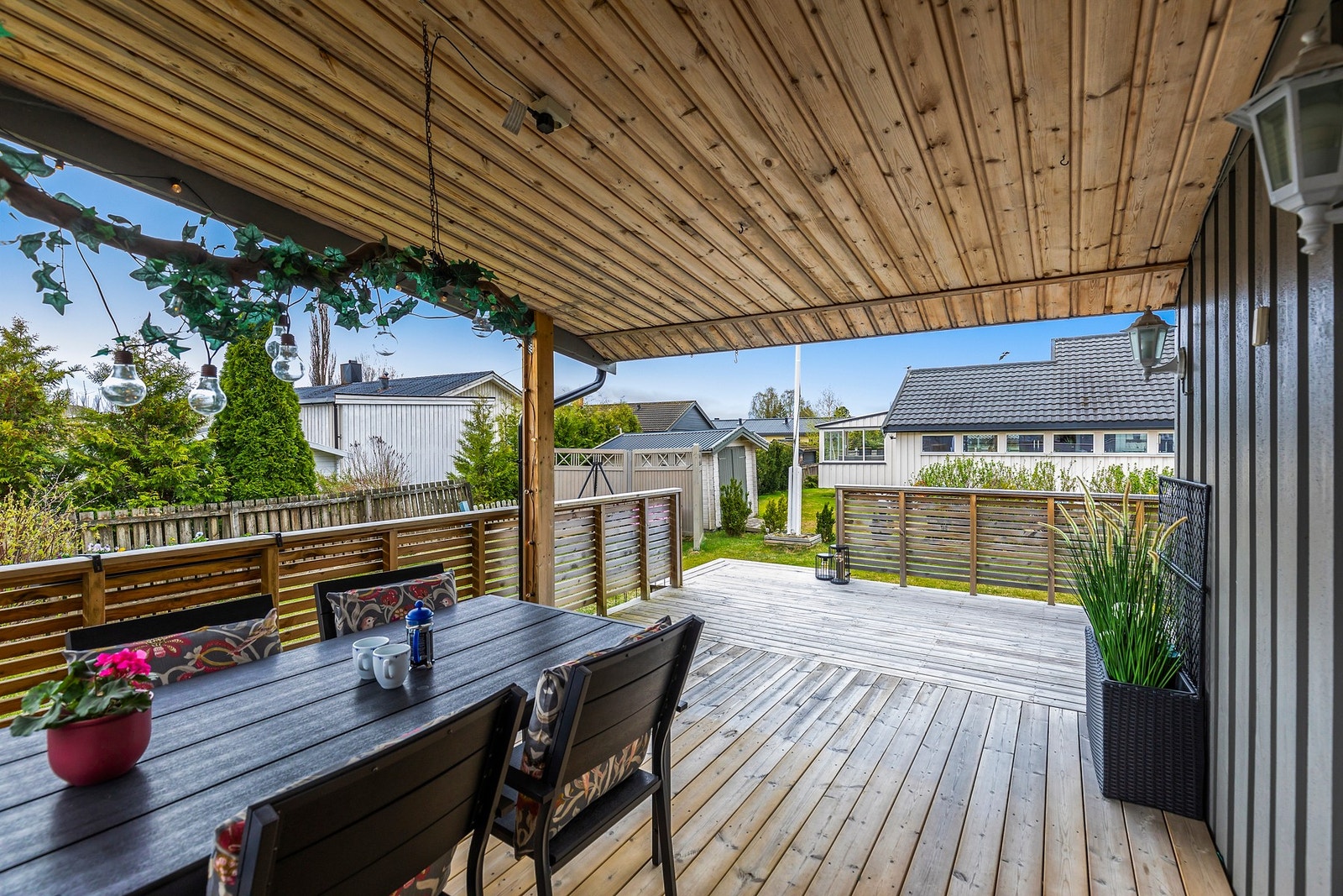 Veranda med både overbygd og åpen del, som gir fleksible uteplasser gjennom dagen. Herfra er det direkte adkomst til en stor hage med gode solforhold. Galleribilde