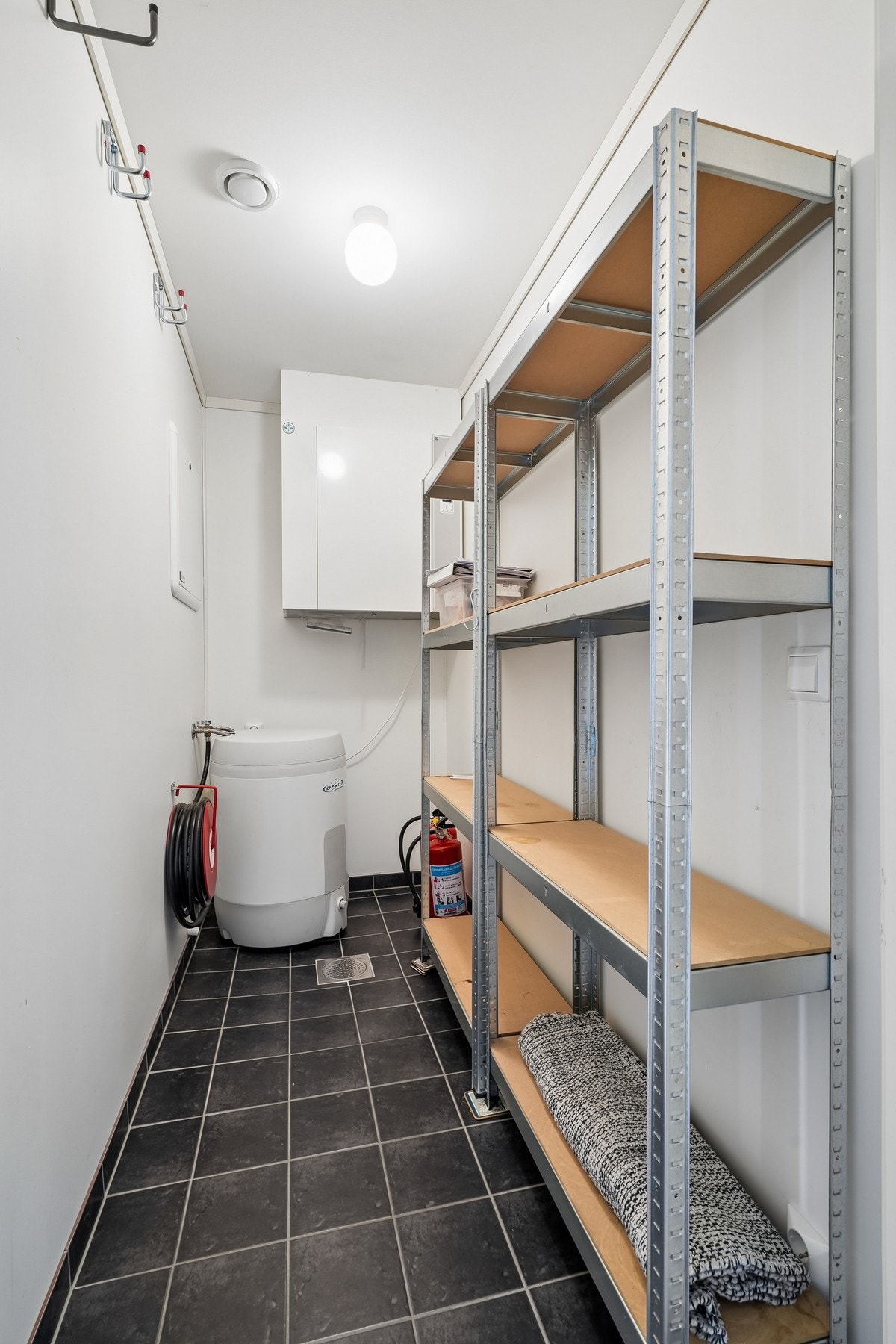 Innvendig flislagt bod med hyller. Galleribilde