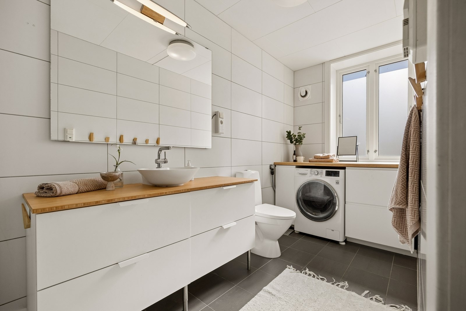 Badet er fra 2013 og gir et pent inntrykk med flislagte overflater, gulvvarme og en god elektrisk vifte i veggen Galleribilde