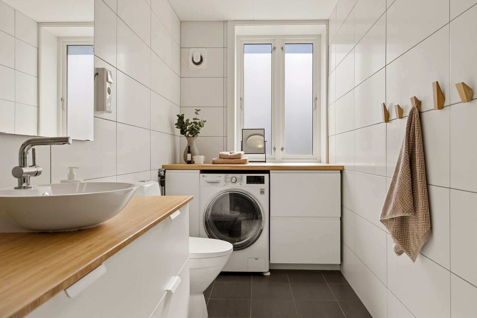 Rommet har opplegg for vaskemaskin og en kombinert vaske- og tørkemaskin. Galleribilde