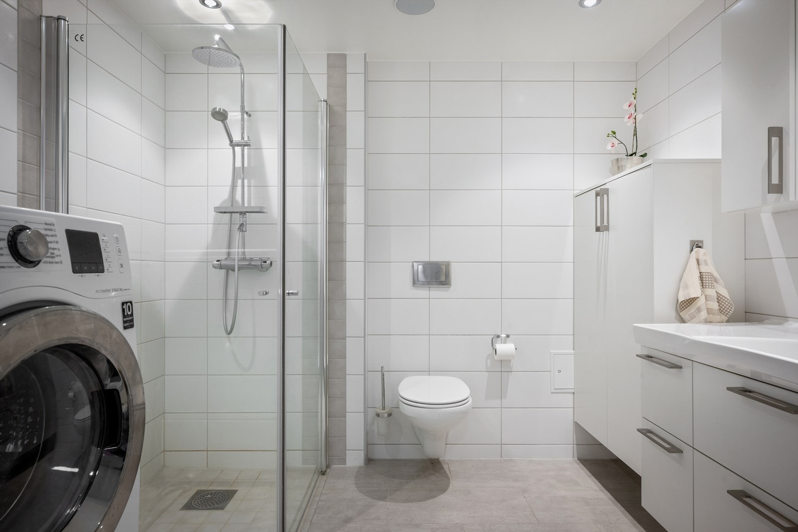 Badet har dusjhjørne med innfellbare glassdører og opplegg for vaskemaskin. Galleribilde