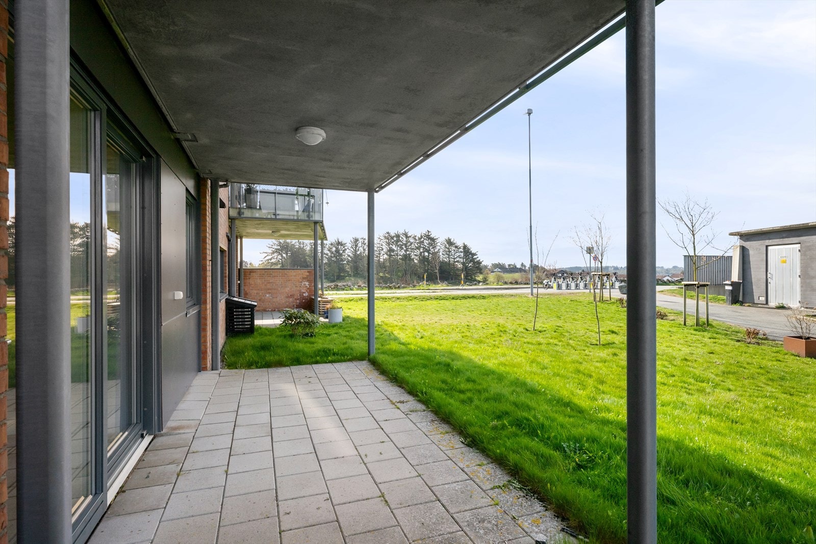 Terrassen er belagt med betongheller og har direkte utgang til borettslagets grøntområder. Galleribilde