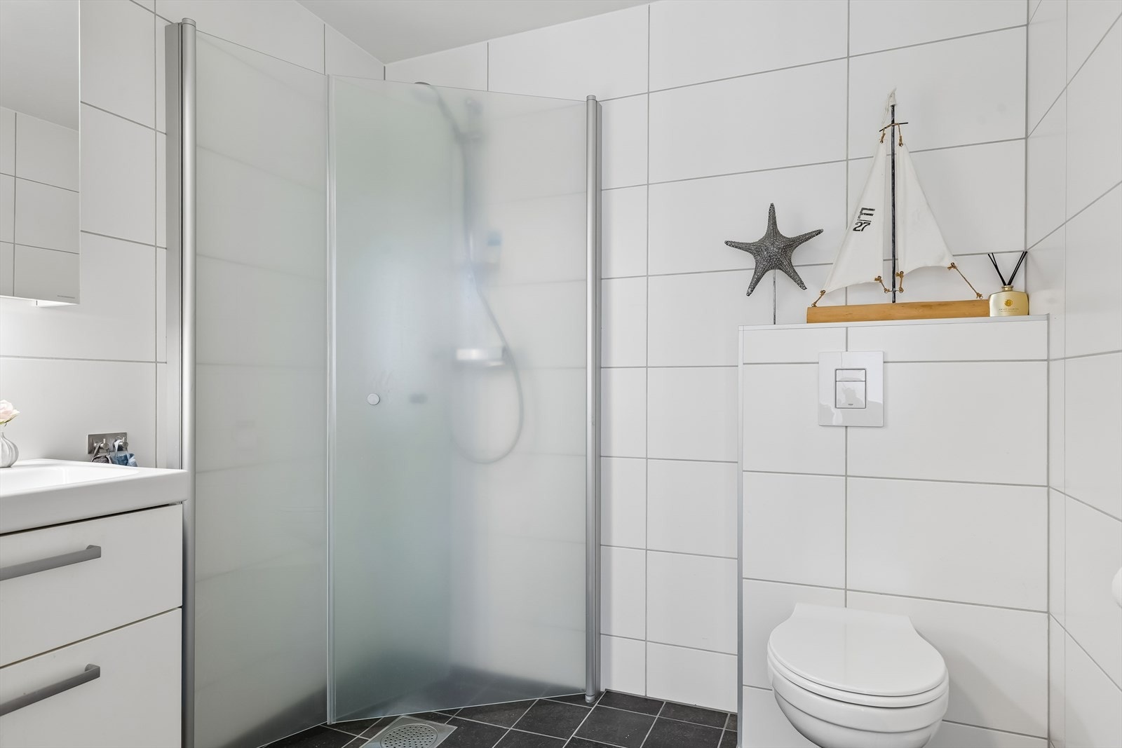 Badet er flislagt og det er varme i gulv. Galleribilde