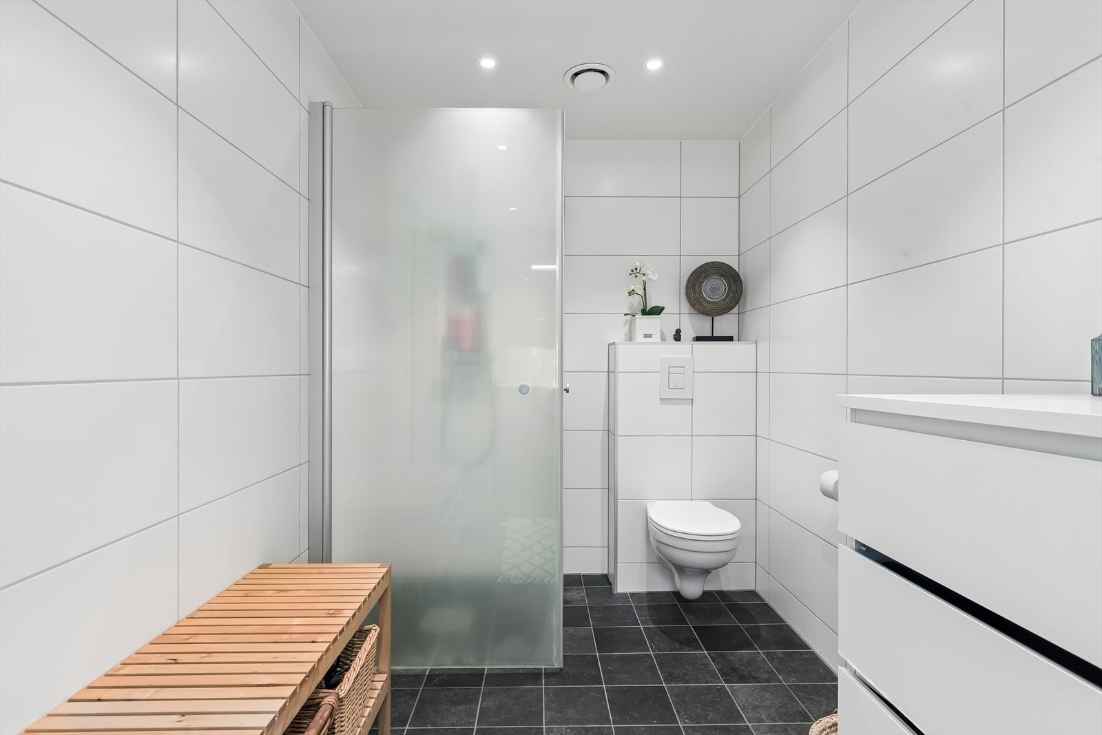 Badet inneholder baderomsinnredning, dusjhjørne og vegghengt toalett. Galleribilde