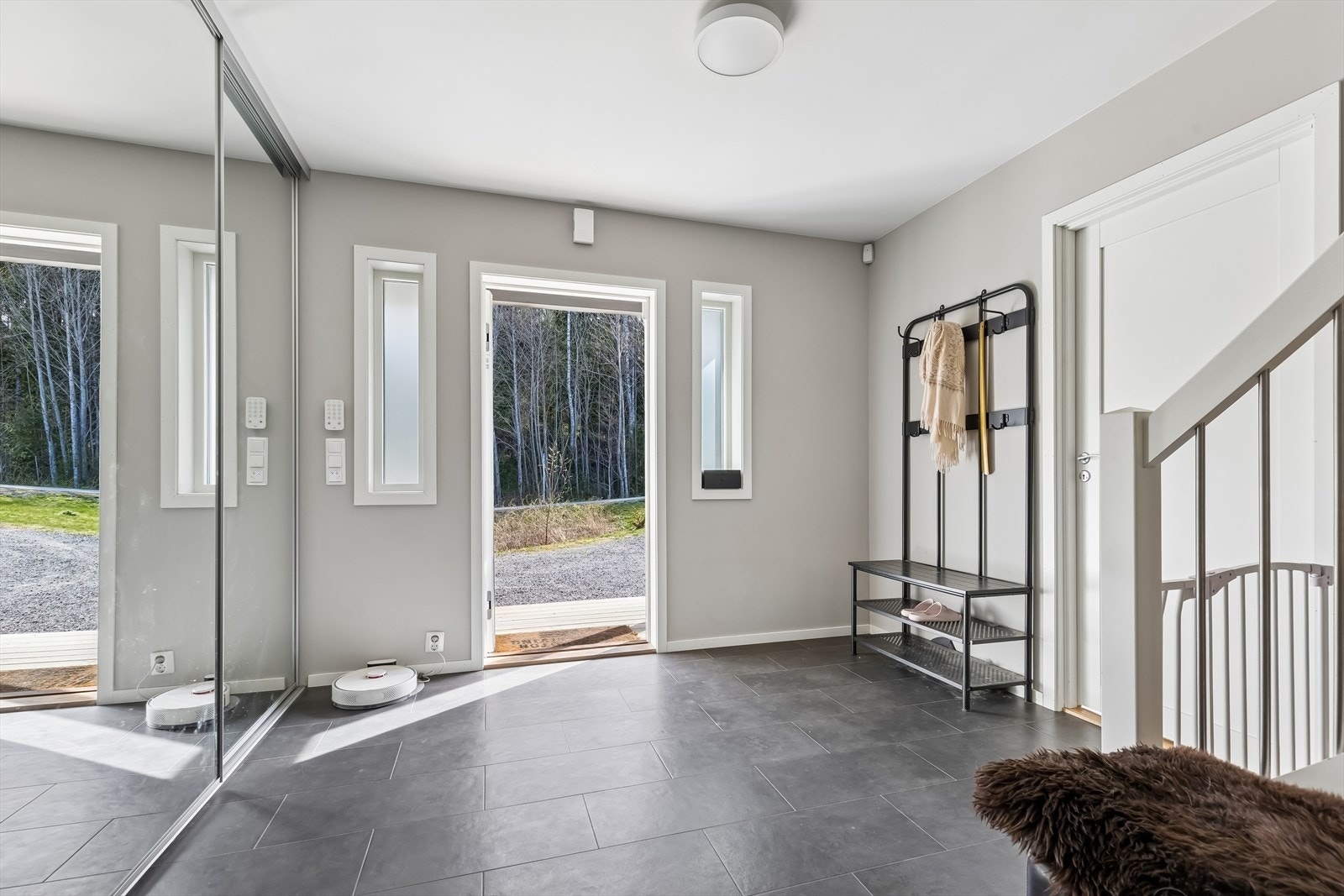 Svært romslig gang med skyvedørsgarderobe. Det er fliser m/varmekabler på gulv. Galleribilde