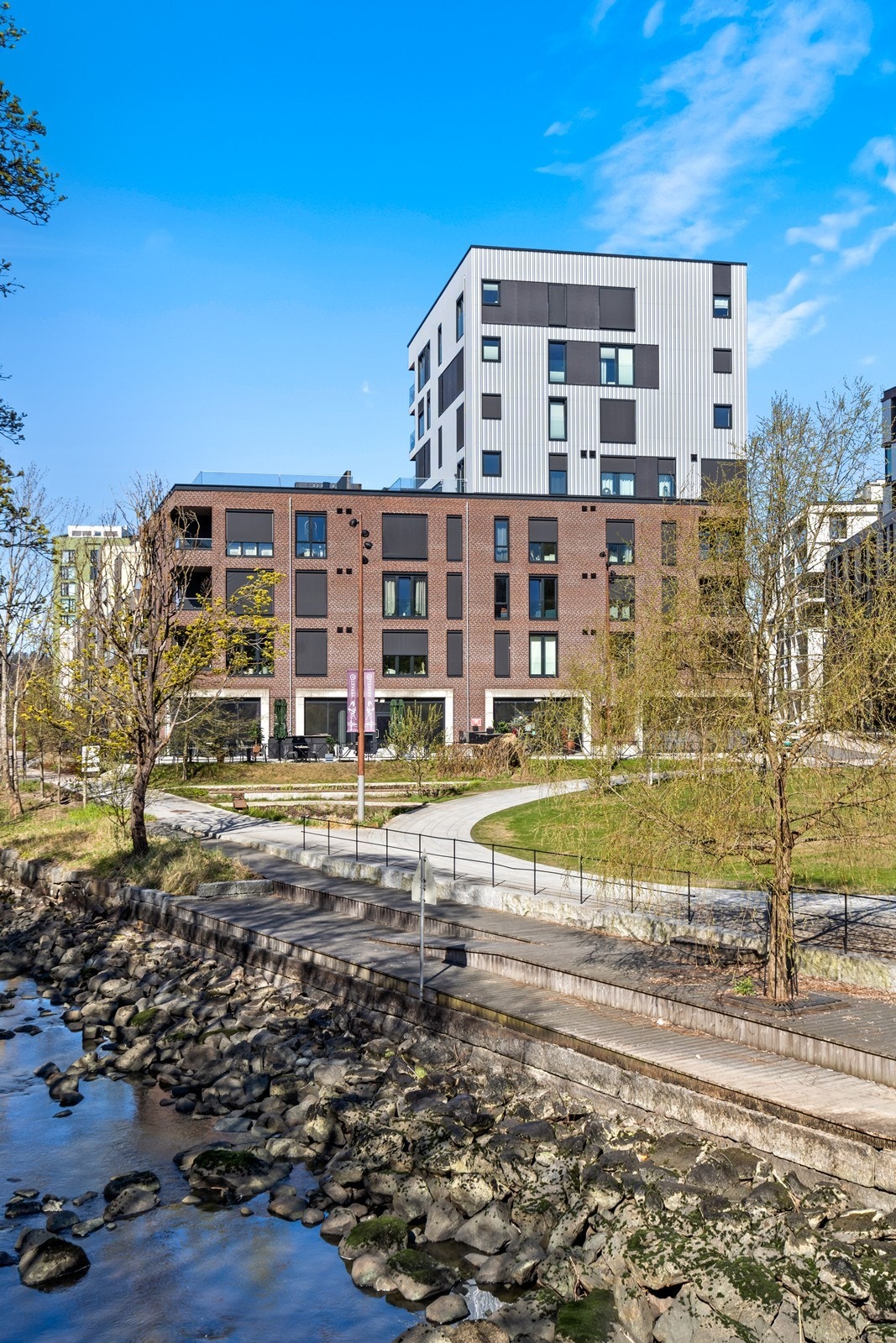 Fellestomten er pent opparbeidet med gangstier og grøntområder langs elven. Galleribilde