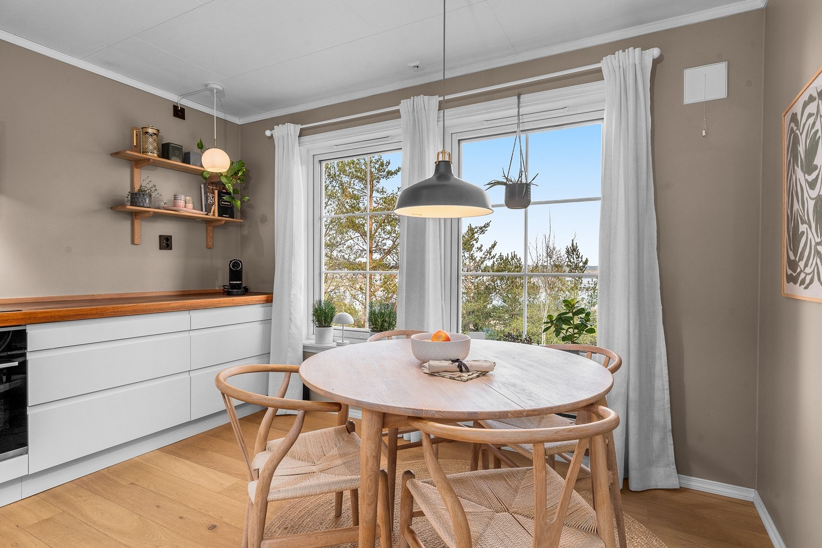 Kjøkkenet har en hyggelig spiseplass ved vinduet, perfekt for frokosten. Galleribilde