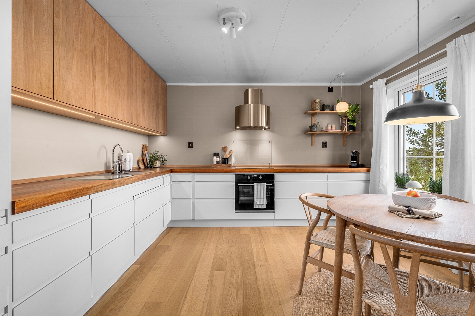 Kjøkkeninnredning fra Norema med glatte fronter og en solid benkeplate i heltre. Galleribilde