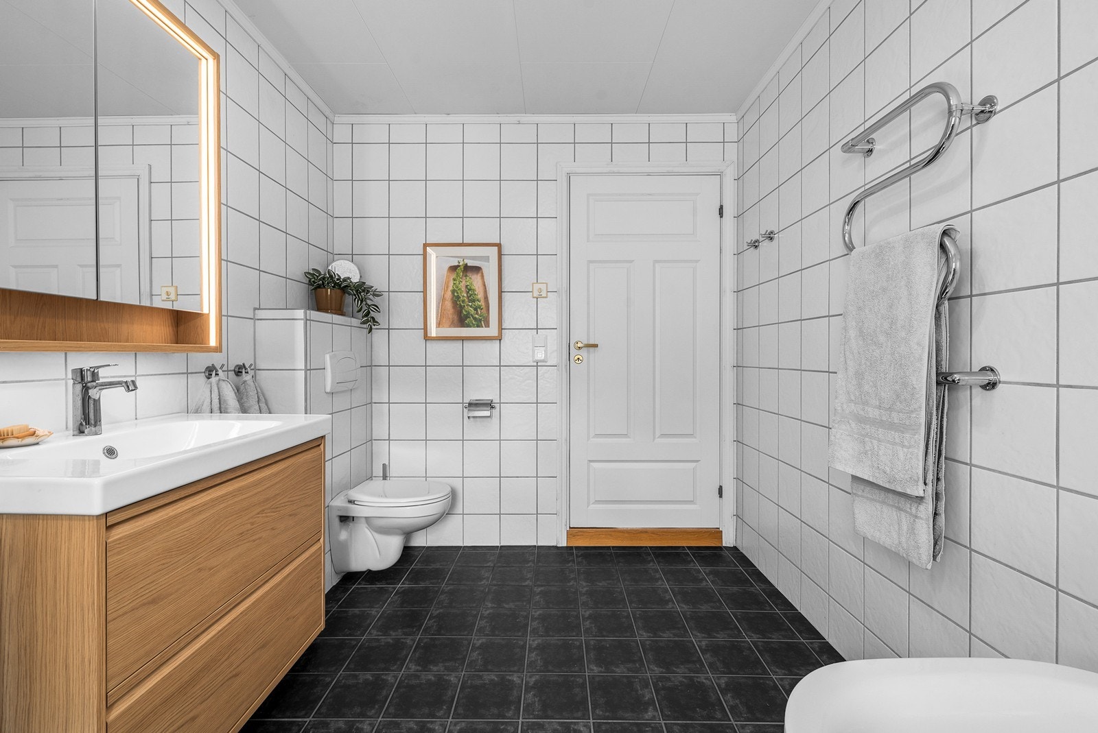 Badet har flislagt gulv med elektriske varmekabler og fliser på veggene. Galleribilde