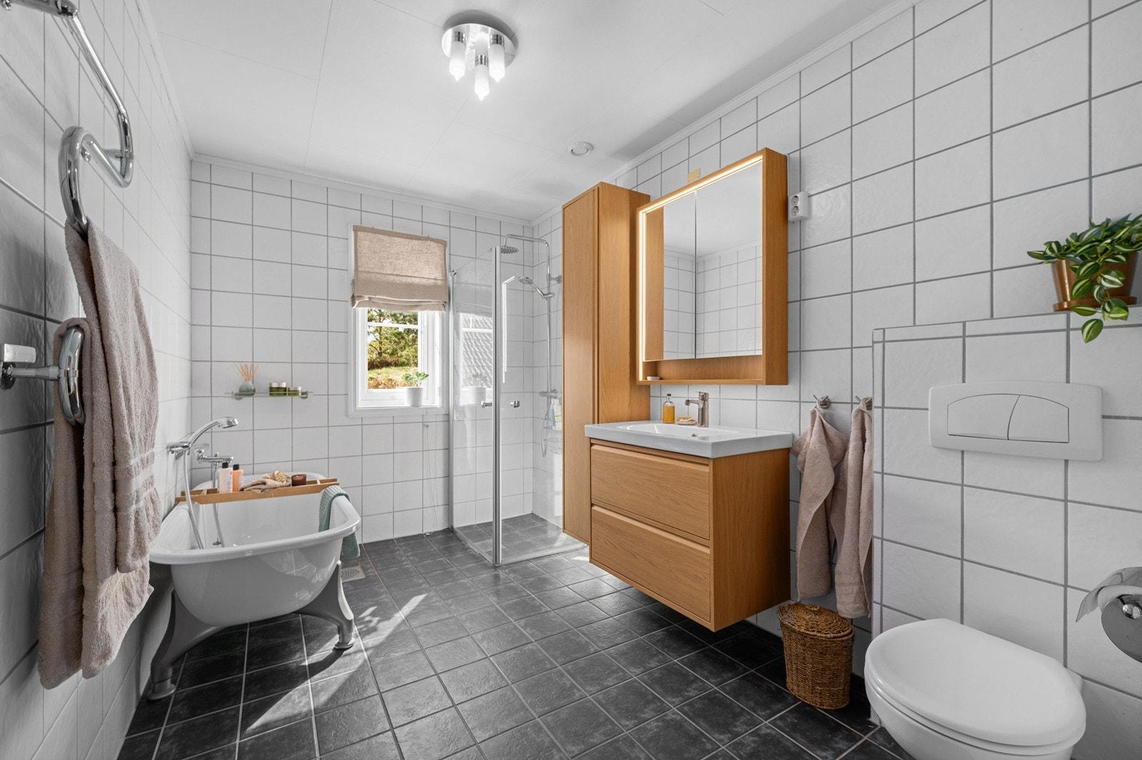 Hovedbadet i første etasje er utstyrt med både dusjhjørne og et frittstående badekar. Galleribilde