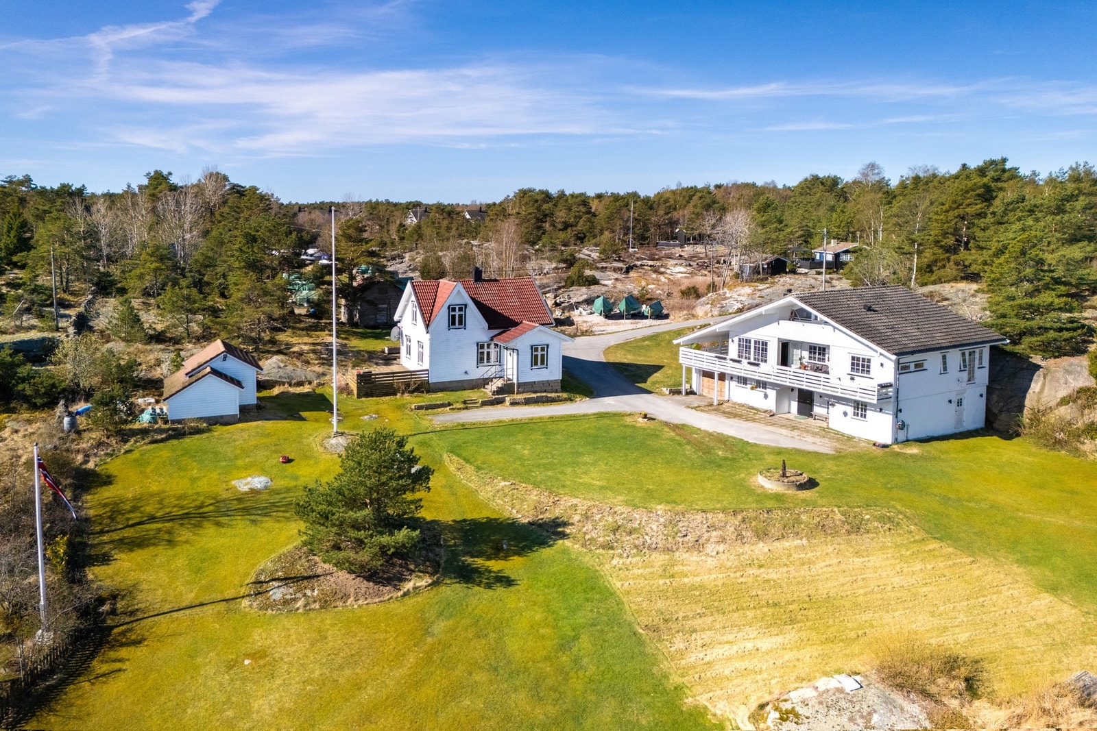 Innholdsrik eiendom med to boliger - hovedbolig og våningshus, i tillegg til flere bygninger fordelt på tomten. Galleribilde