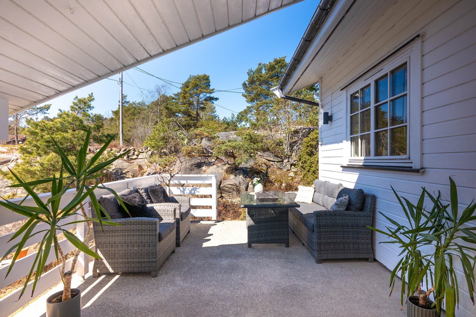 Flere flotte og solrike uteplasser på eiendommen. Her sett på den ene terrassen på hovedboligen. Galleribilde