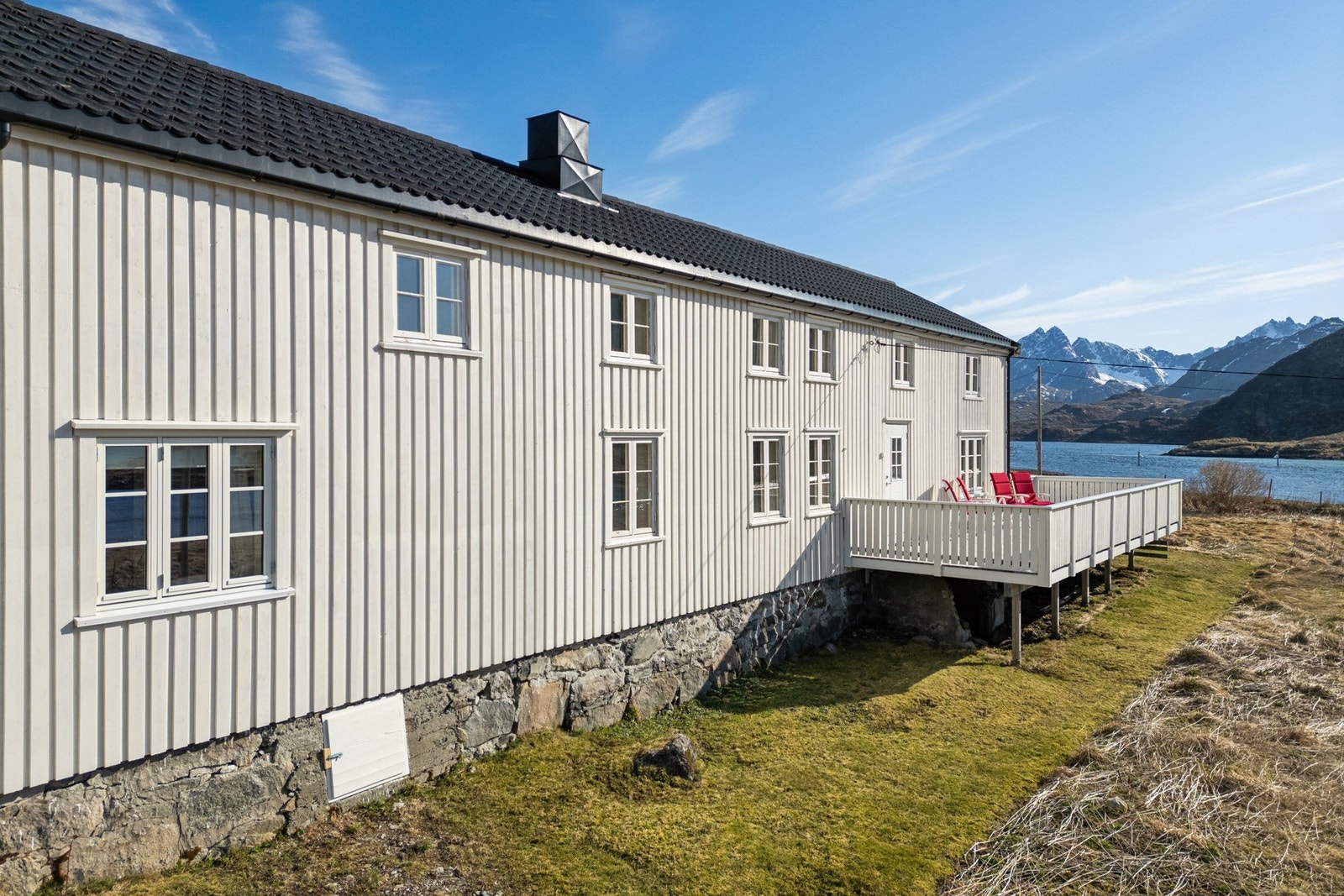 En sjelden beliggenhet med sjøen som nærmeste nabo og panoramautsikt mot Lofotens karakteristiske fjell. Galleribilde