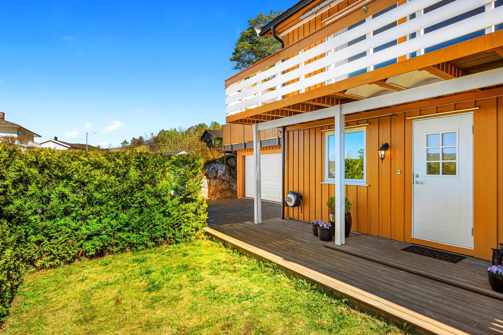 Uteområdet ved inngangspartiet på vestsiden består av en terrasse samt en skjermet og barnevennlig gressplen omkranset av hekk. Området oppleves privat og trygt, og er tilrettelagt for lek med blant annet sandkasse. Galleribilde