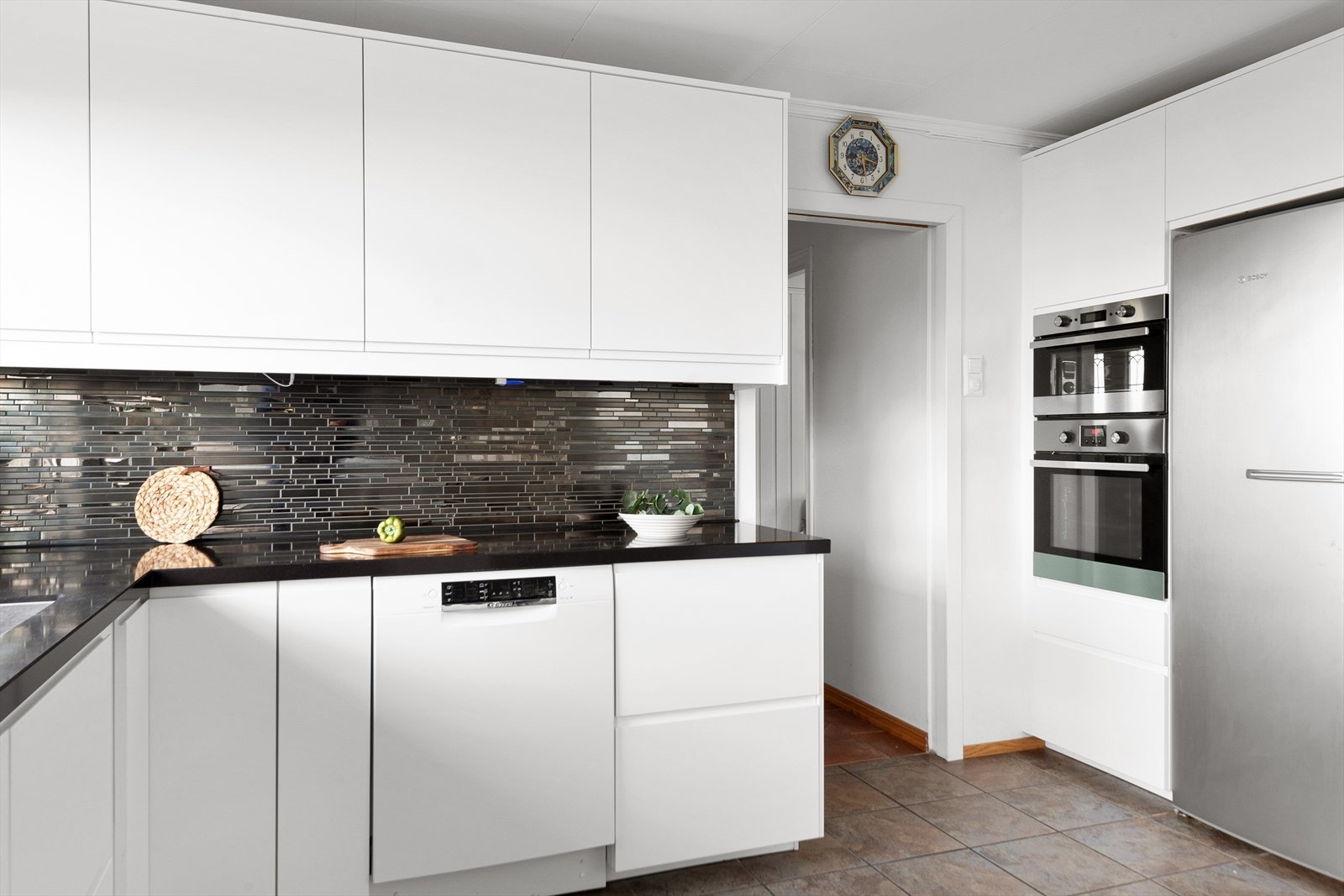 Moderne innredning fra IKEA (2020) med hvite, glatte fronter og mørk, laminat benkeplate. Galleribilde