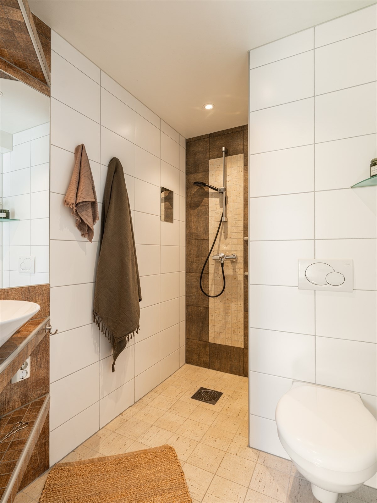Pent og tidsriktig baderom fra 2014 med flislagt gulv med varme, flislagte vegger og malt himling med downlights. Galleribilde