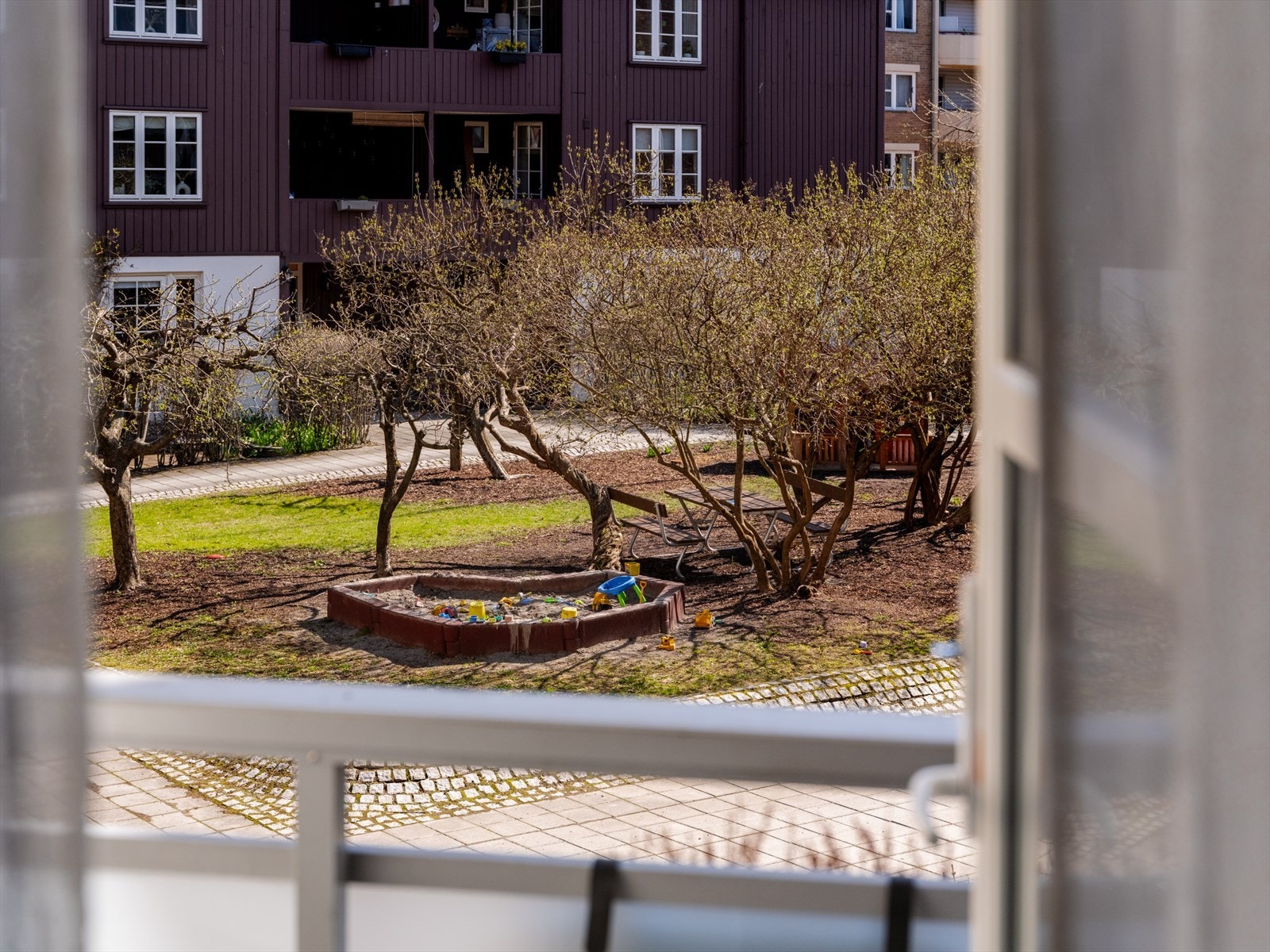 Utsikt mot indre gårdsrom fra balkong. Gårdsrommet er skjermet og pent opparbeidet. Her trives både store og små. Galleribilde