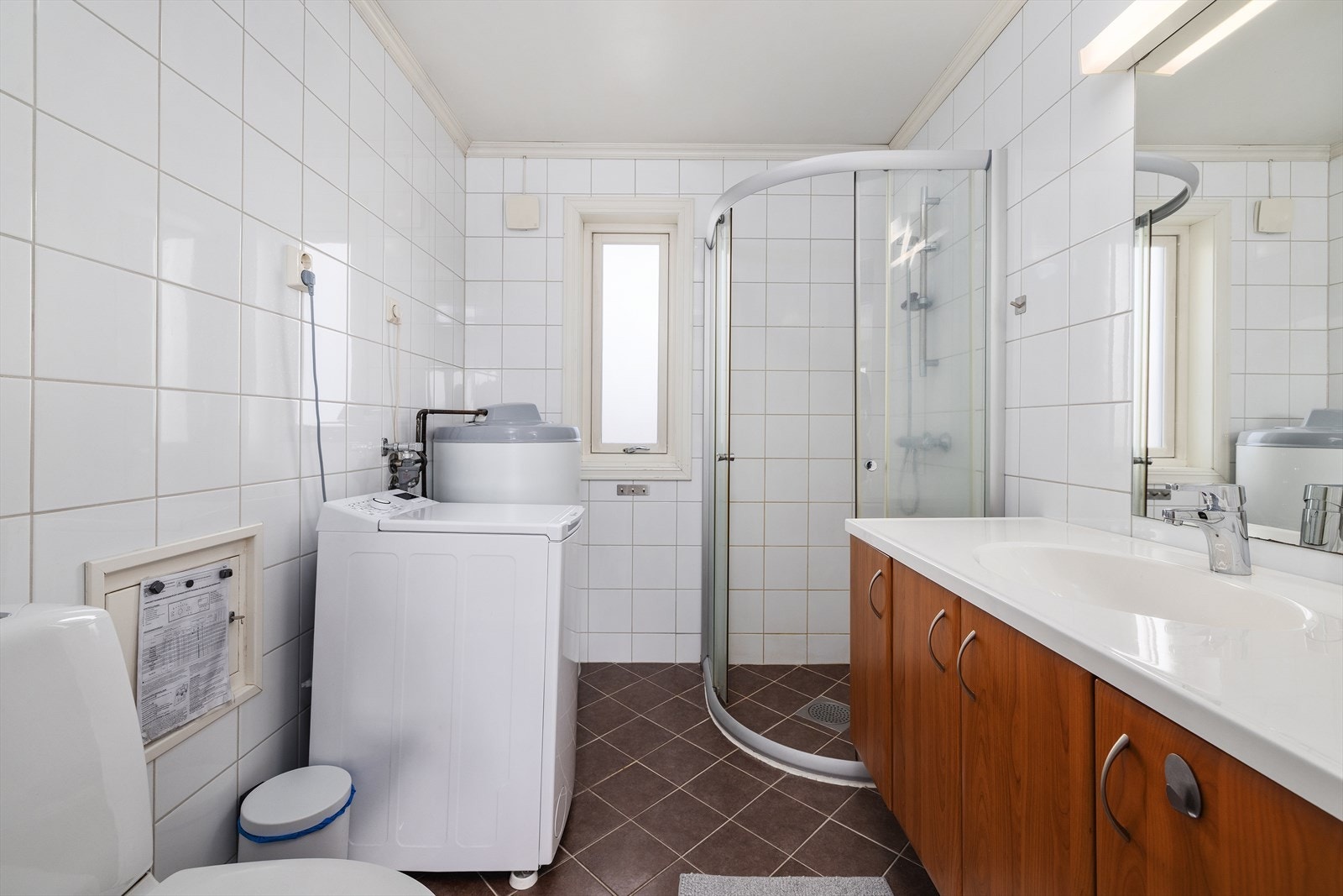 Badet i utleiedelen har flislagt gulv med gulvvarme, dusjhjørne og opplegg for vaskemaskin. Galleribilde