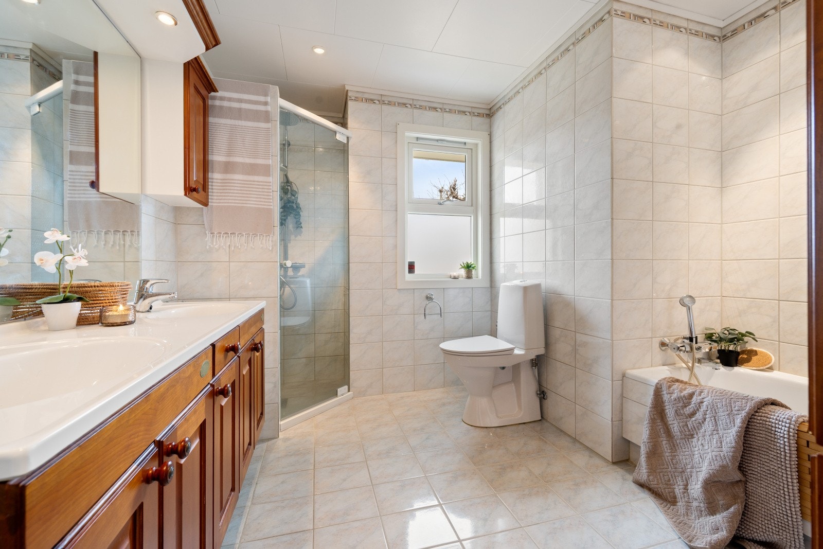 Badet i første etasje er fra 1997 og er utstyrt med heldekkende dobbel servant på underskap, speil, belysning, klosett og badekar. Galleribilde