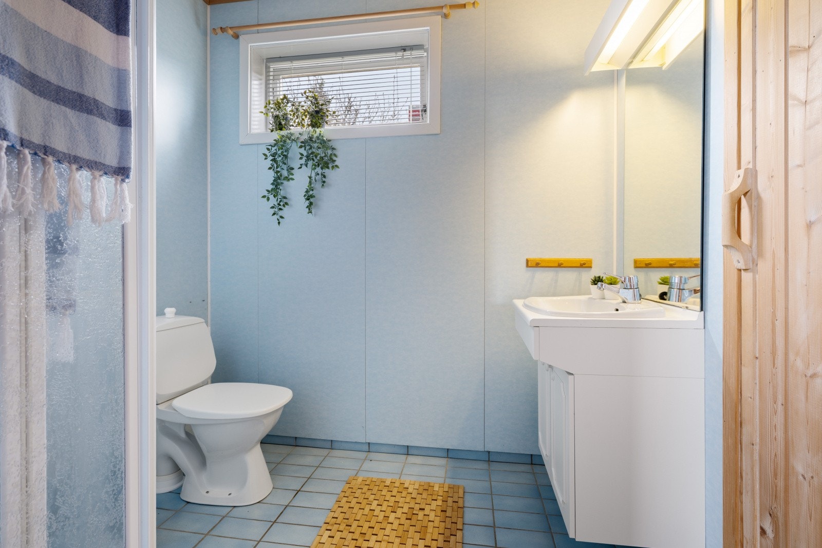 Badet i kjelleren er fra 1991 og utstyrt med nedfelt servant i underskap, speil, belysning, klosett og dusj. Galleribilde