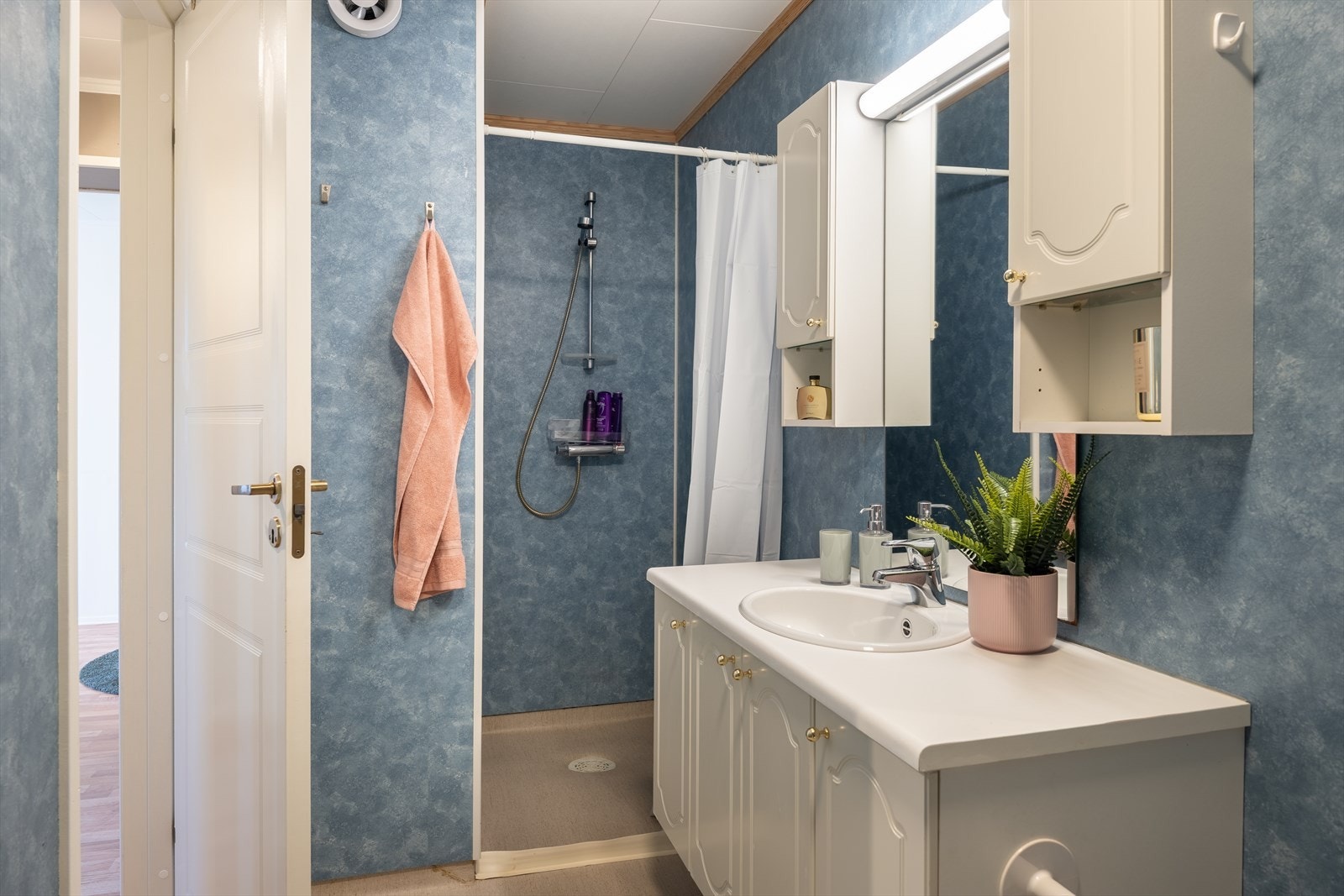 Badet er utstyrt med vegghengt skap, dusjnisje, toalett og opplegg for vaskemaskin. Galleribilde
