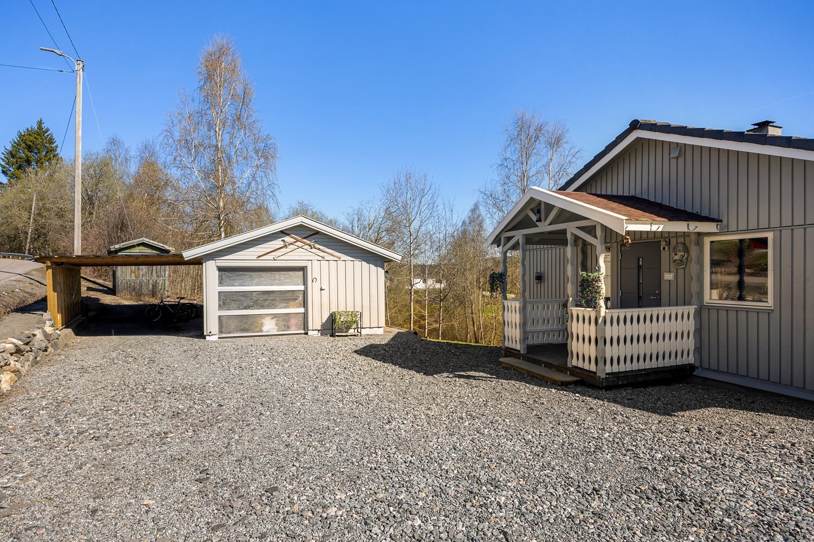 Eiendommen har en frittstående garasje på ca. 28 kvm, med sidedør, elektrisk portåpner og tilbygget carport. Carporten står over tomtegrensen. Det er flere parkeringsmuligheter på den gruslagte gårdsplassen. Galleribilde