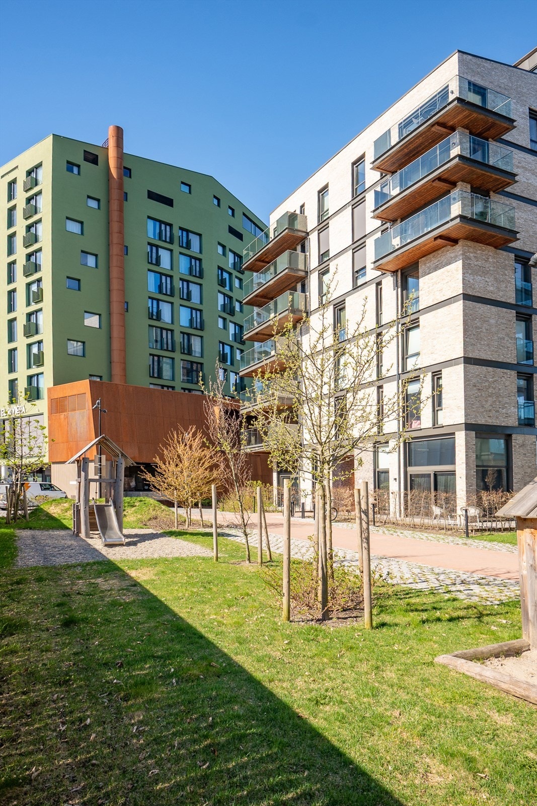 Fellesområdet i sameiet er innbydende med gressplen, steinheller, belysning, benker, lekeapparater og beplantning. Galleribilde