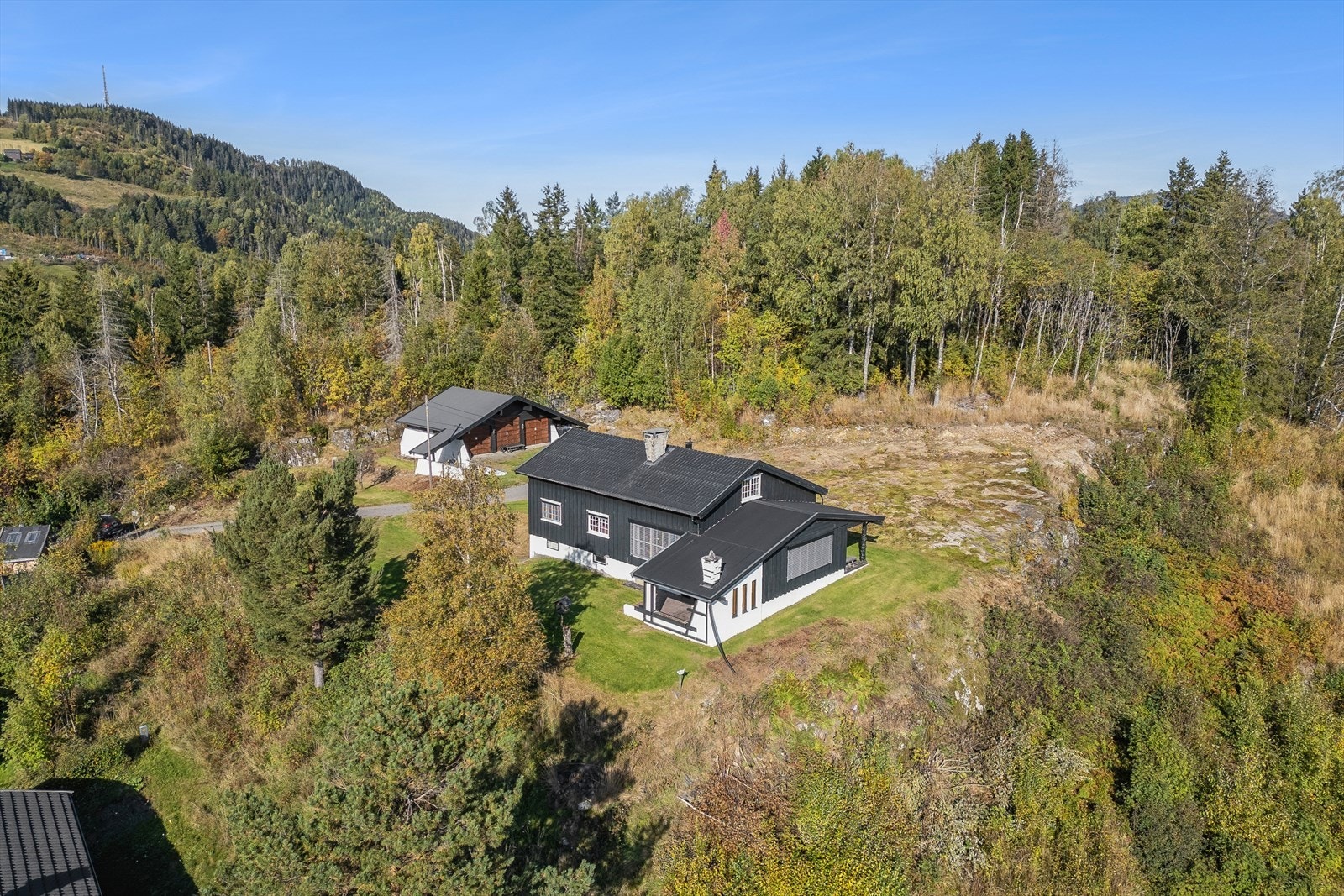 Tomten er flat og lett skrånende, med gruset adkomst og en stor gårdsplass. Galleribilde