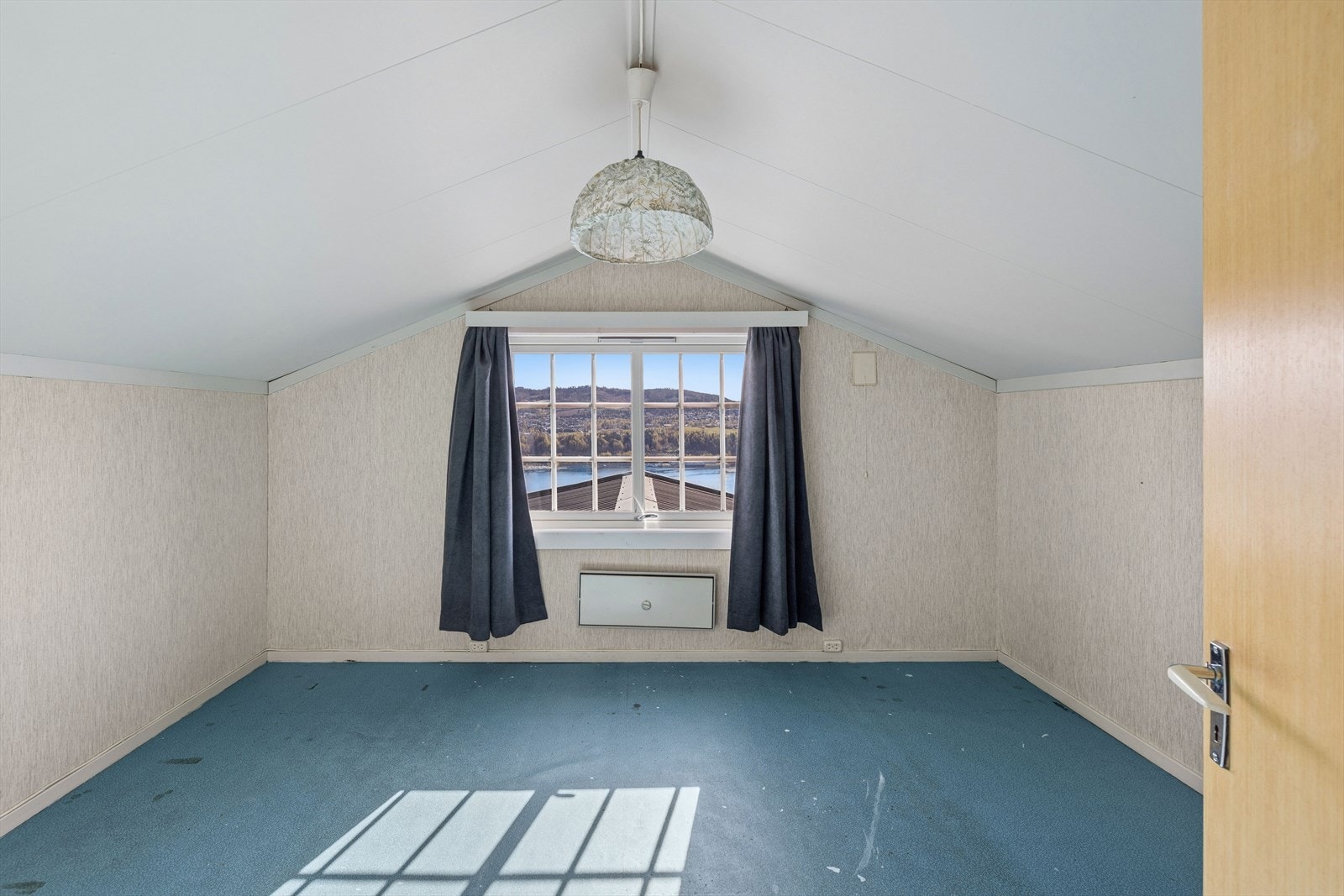 I andre etasje ligger to soverom. Dette rommet har teppe på gulvet og utsikt mot Mjøsa. Galleribilde