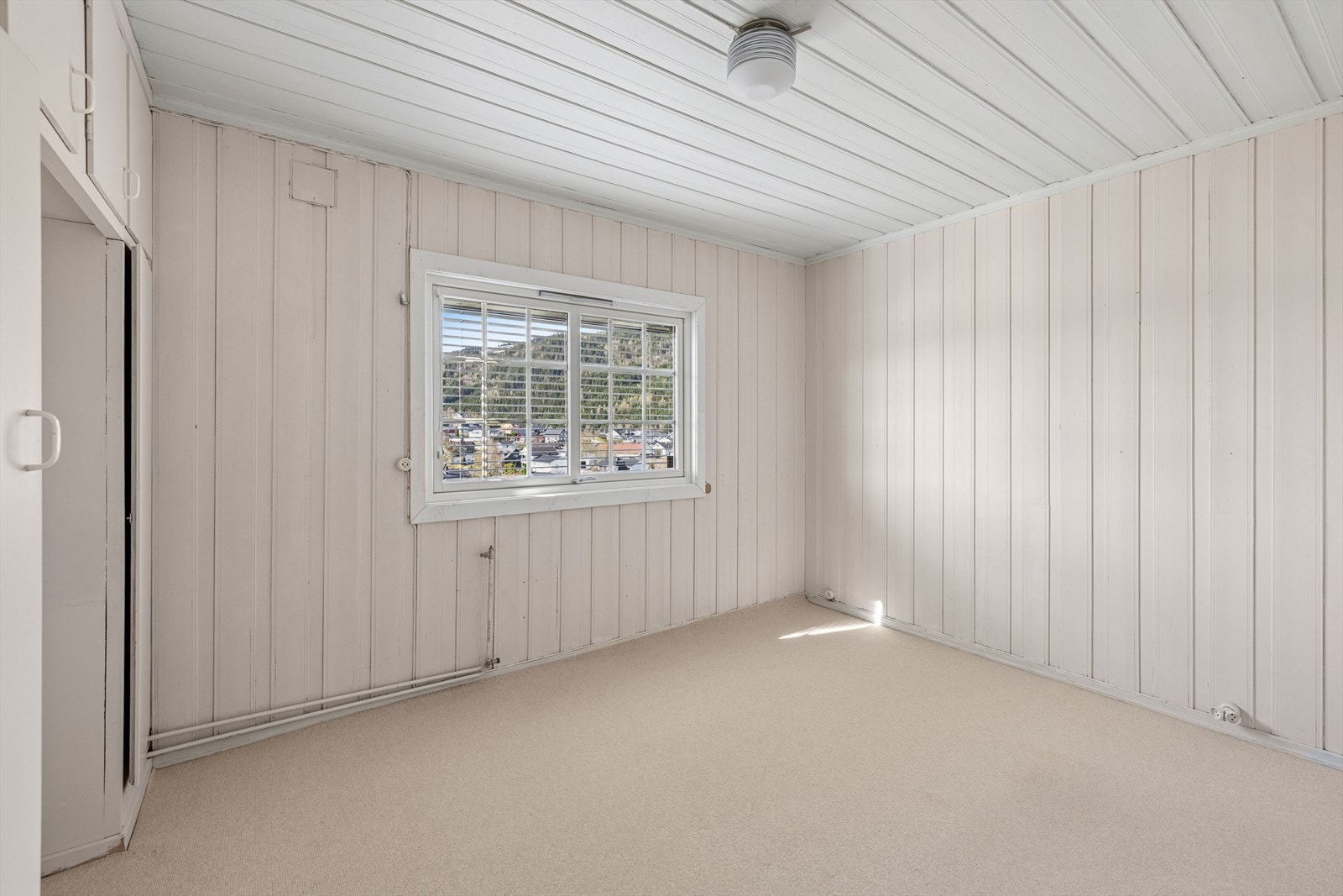 Soverommet har teppe på gulvet og panel på vegger og i tak. Galleribilde