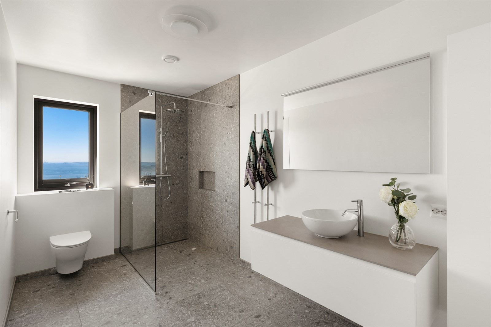 Badet i første etasje har flislagt gulv med vannbåren varme, vegghengt toalett og en romslig dusjsone med slukrenne. Galleribilde