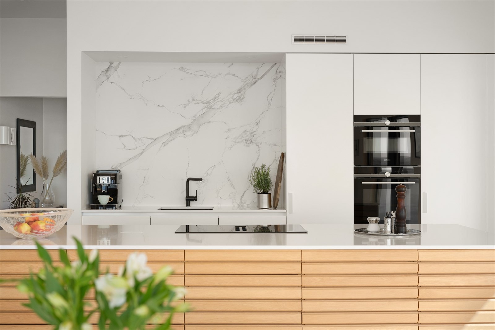 Kjøkkenet er velutstyrt med blant annet stekeovn og kombiovn i arbeidshøyde. Benkeplaten er av slitesterk Silestone. På vegg i kjøkkennisjen er det Dekton steinplate. Galleribilde