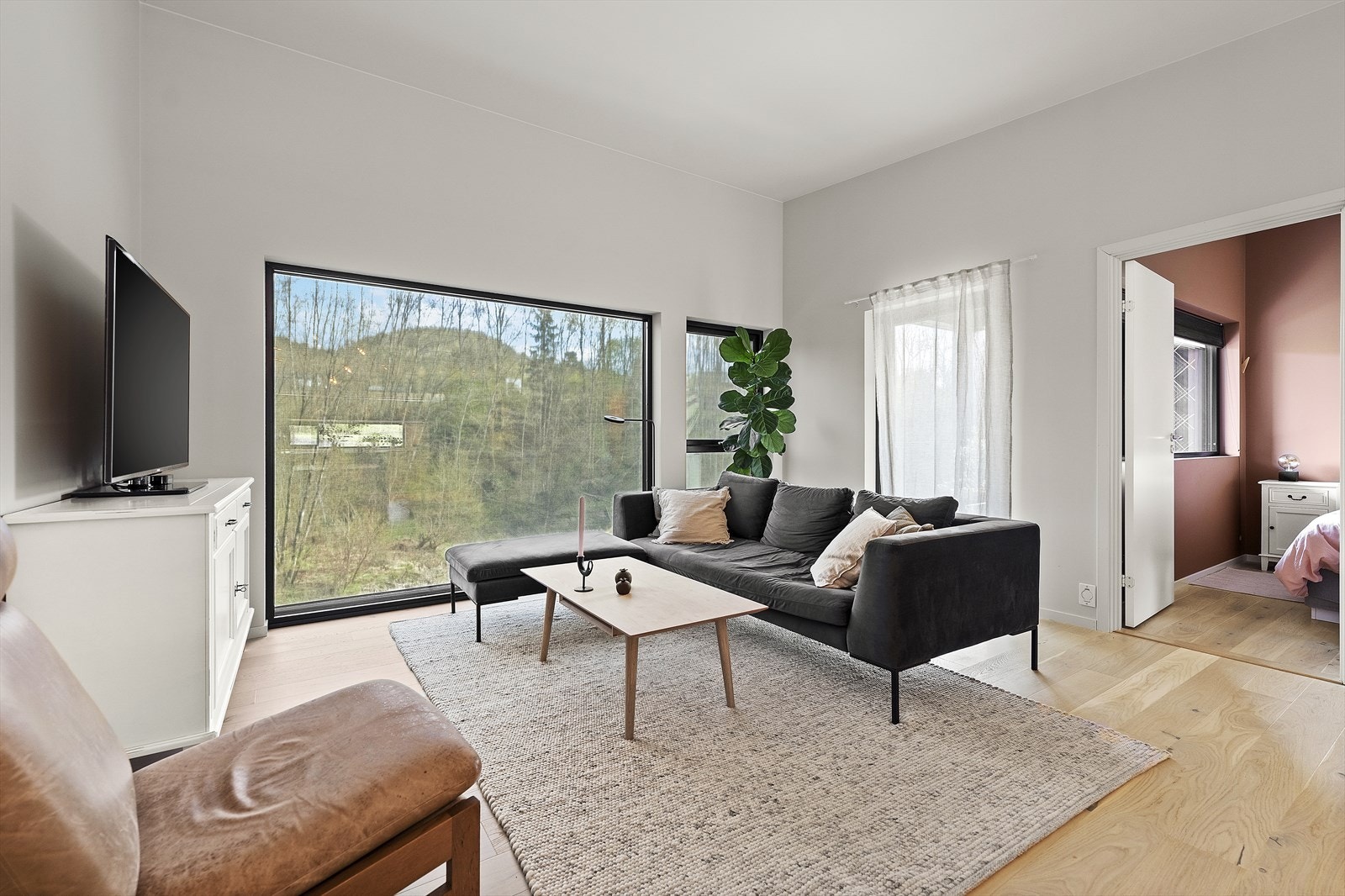 Lys og romslig stue med store vindusflater som slipper inn godt med dagslys Galleribilde