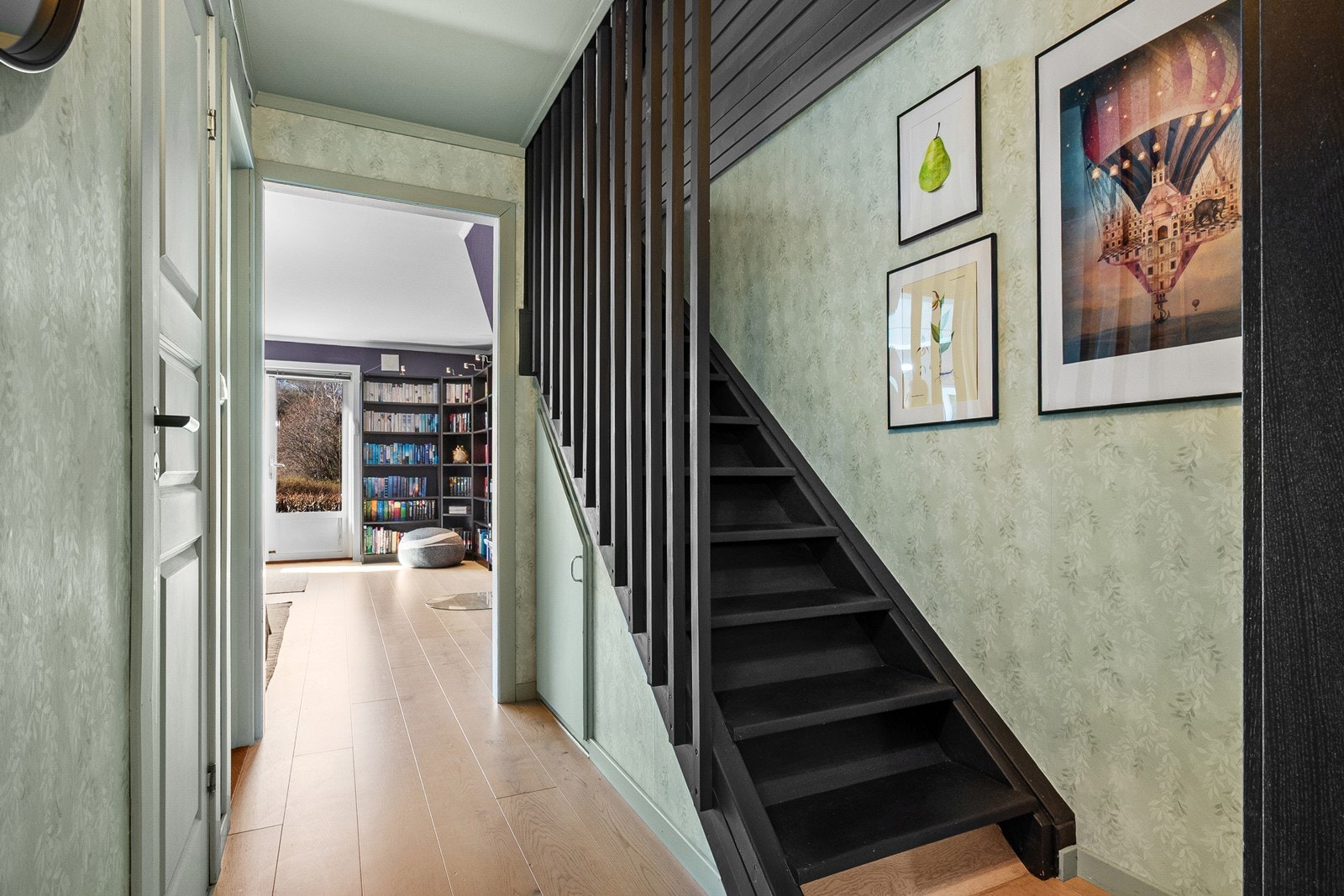 Fra gangen fører lukket trapp opp til boligens 2. etasje, med praktisk lagringsplass under. Galleribilde