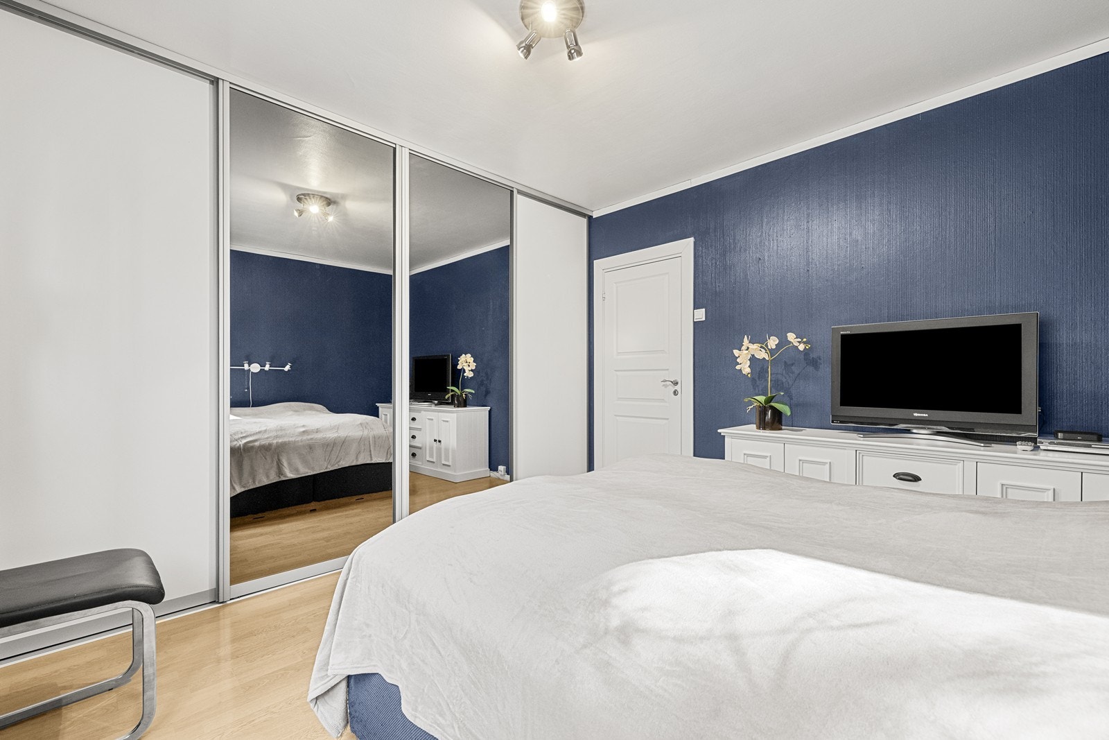 En stor skyvedørsgarderobe med speilfronter gir rikelig med oppbevaringsplass. Galleribilde