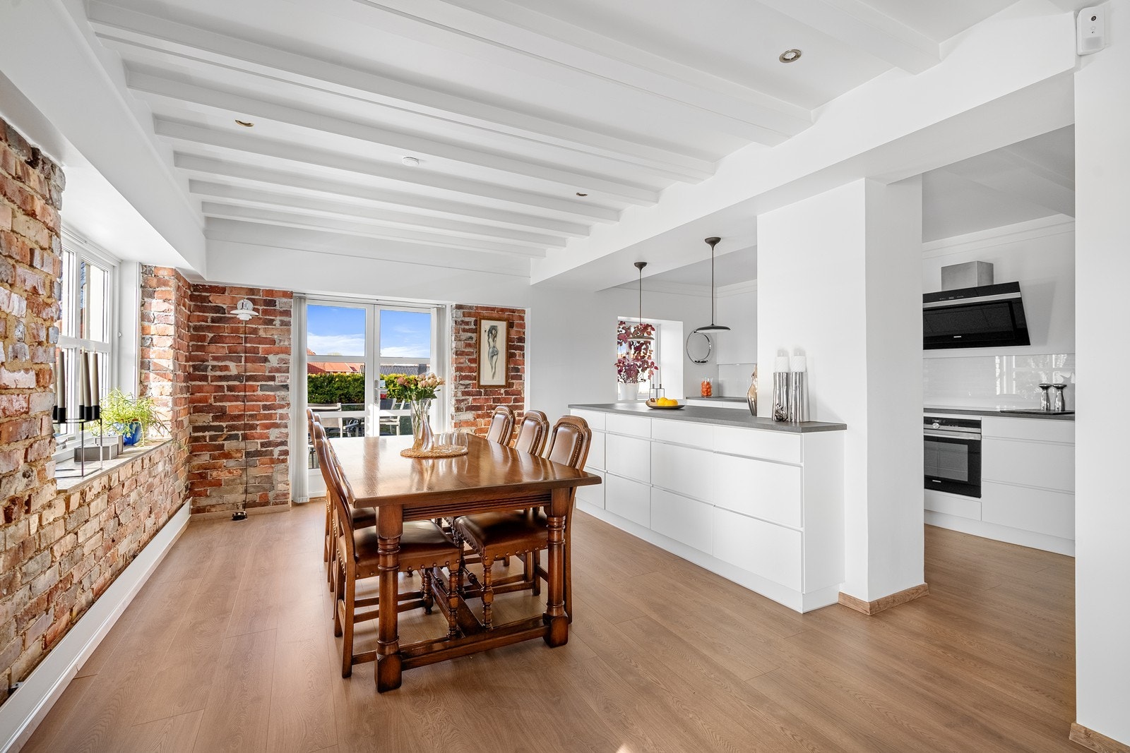 1. etg: Vakker miks av modernisert kjøkken, hvitmalte overflater og original teglstein. Utg til vestvendt terrasse. Galleribilde