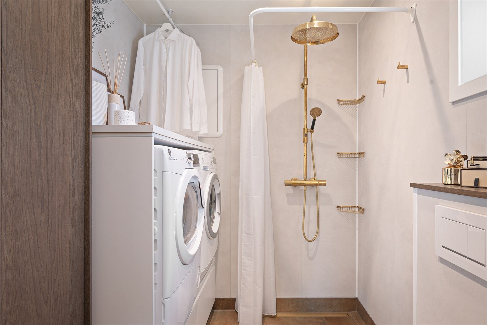 Badet er kombinert vaskerom med innredning fra HTH og med en praktisk dusjnisje og plass til vaskesøyle. Her er kran, regndusj, såpehyller og knagger fra Tapwell. Galleribilde
