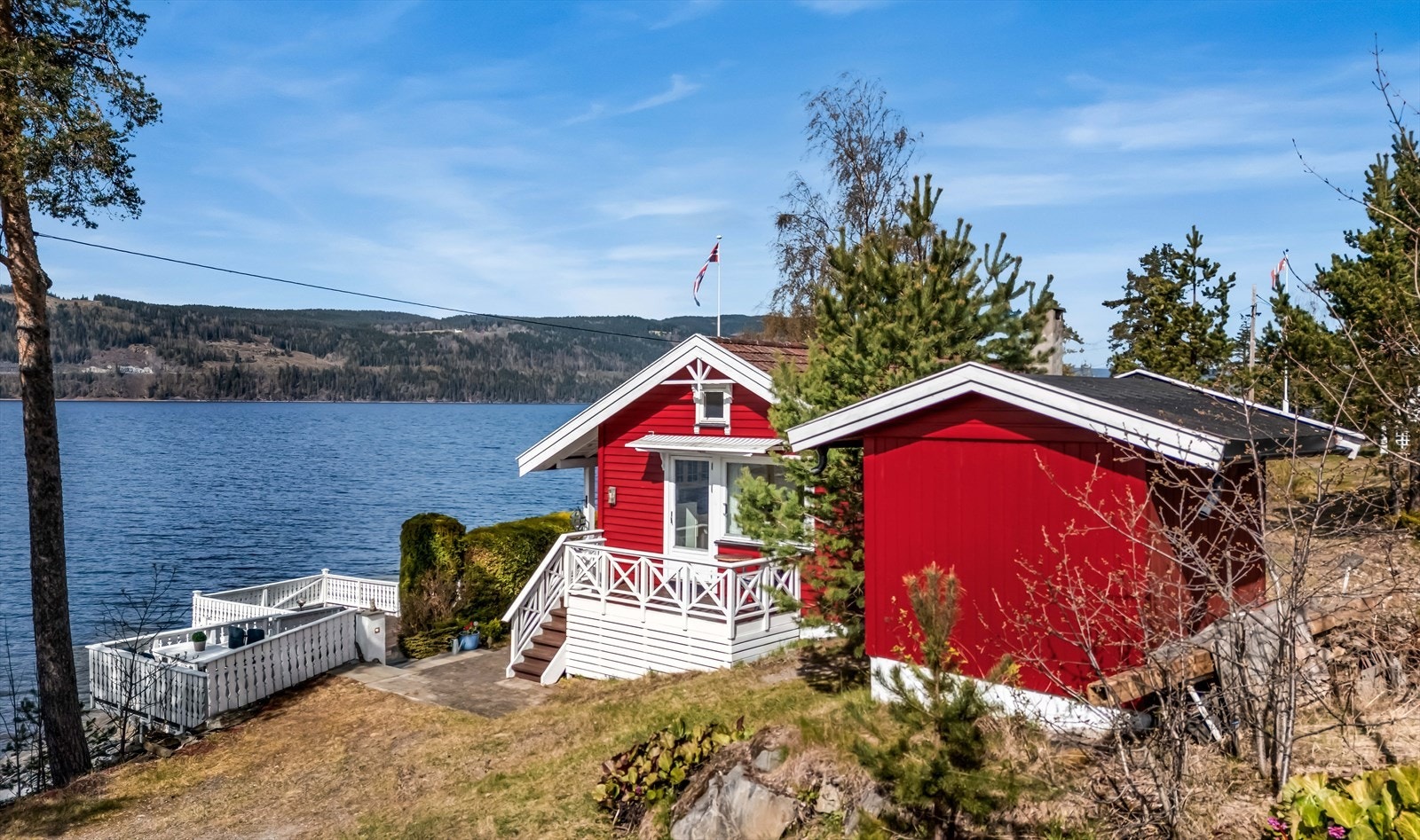 Fritidsboligen og gjestehuset sett fra siden, med Mjøsa som bakteppe. Galleribilde