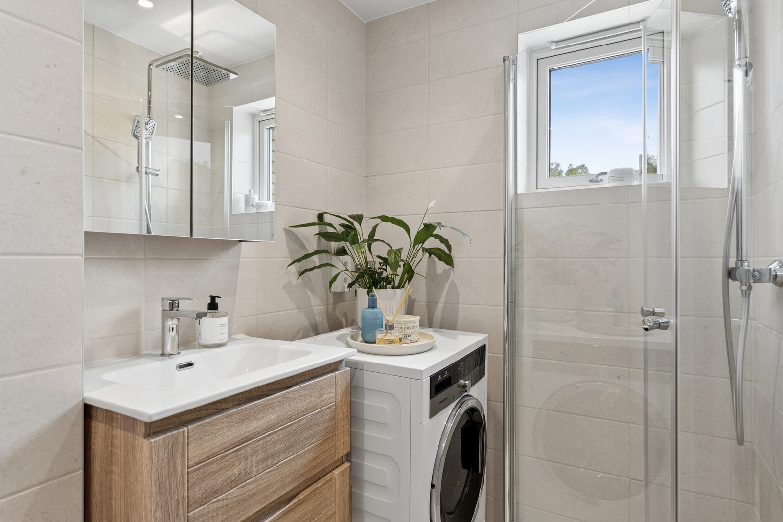 Delikat baderom renovert i regi av borettslaget i 2026. Badet har moderne og pen innredning, opplegg for vaskemaskin, dusjhjørne og toalett. Galleribilde