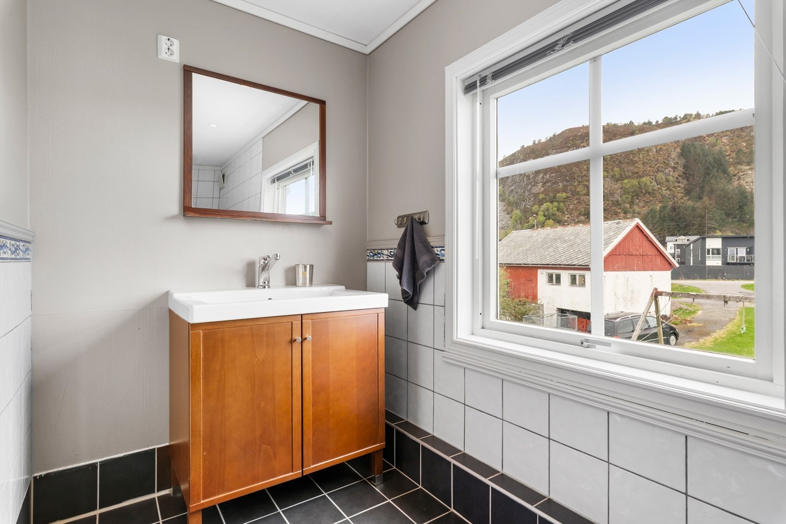 Badet har fliser på gulvet med varmekabler, innredning med nedfelt servant og dusjkabinett. Galleribilde