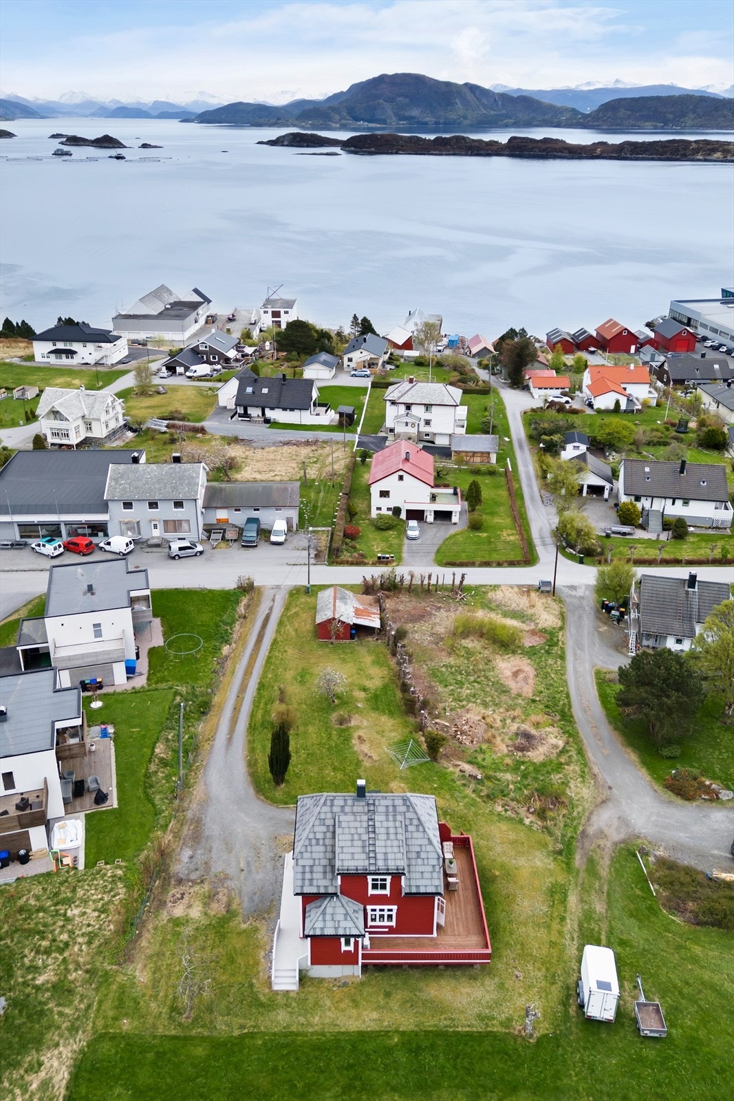 Tomten ligger i lett skrånende terreng og er opparbeidet med beplantning, plen, støpt platting og støpt trapp. Galleribilde