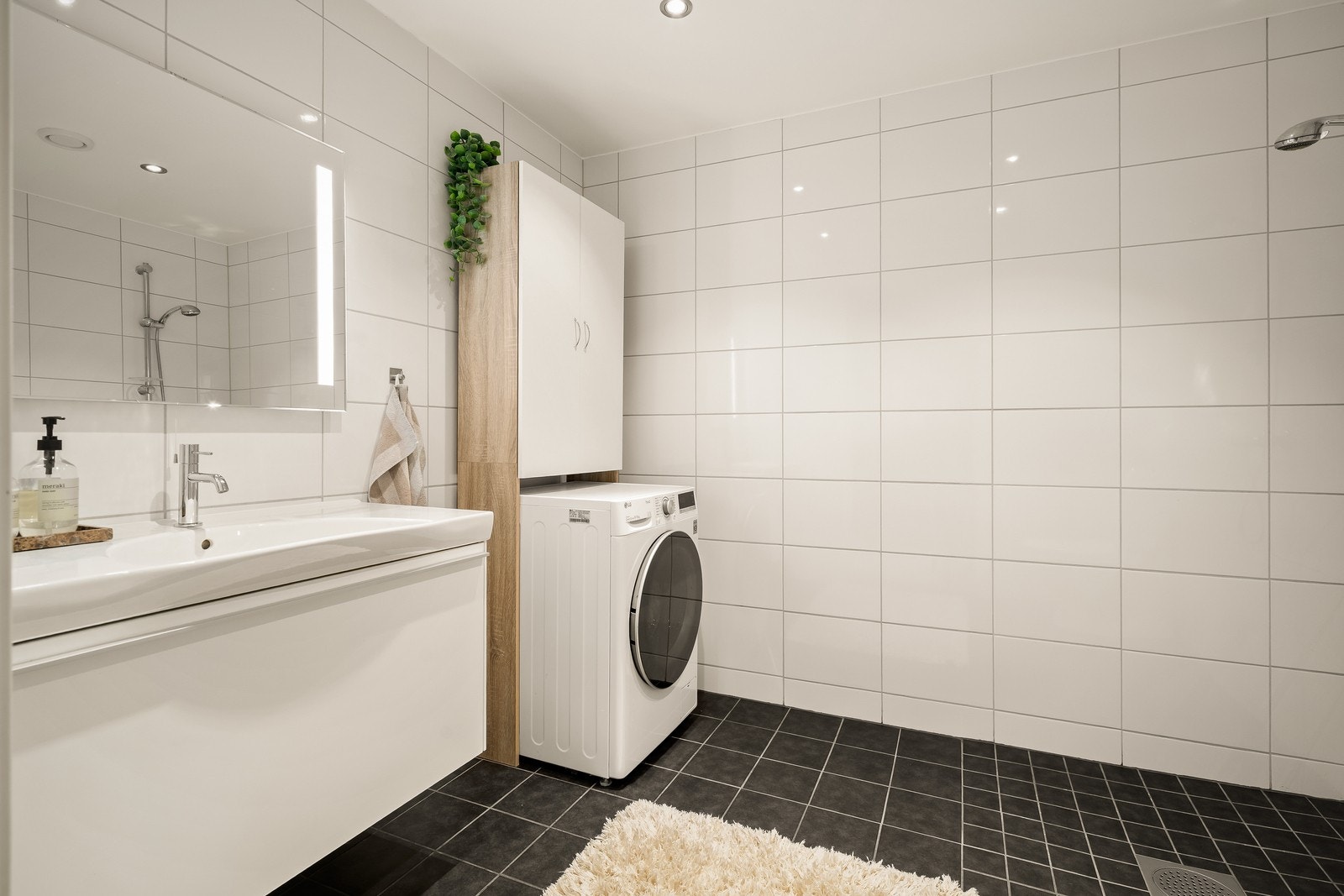 Baderommet i 2.etasje er utstyrt med servantinnredning, opplegg for vaskemaskin, dusjhjørne og Wc på sokkel. Galleribilde