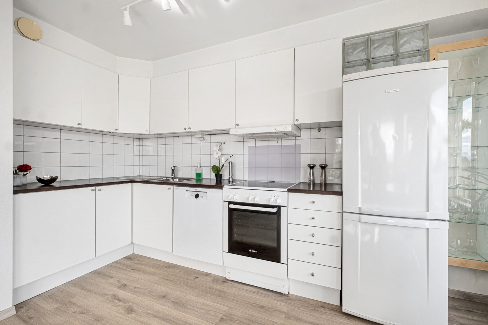 Løsningen er godt utnyttet med rikelig skap- og benkeplass. Laminat benkeplate med fliser på vegg. Galleribilde