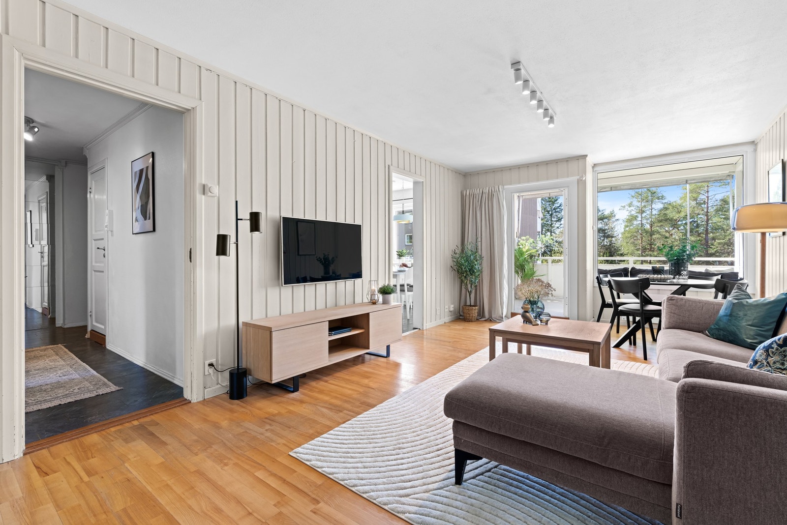 Stuen har parkett på gulvet og fin plass til å innrede med sofa, tv og tilhørende møblement. Galleribilde