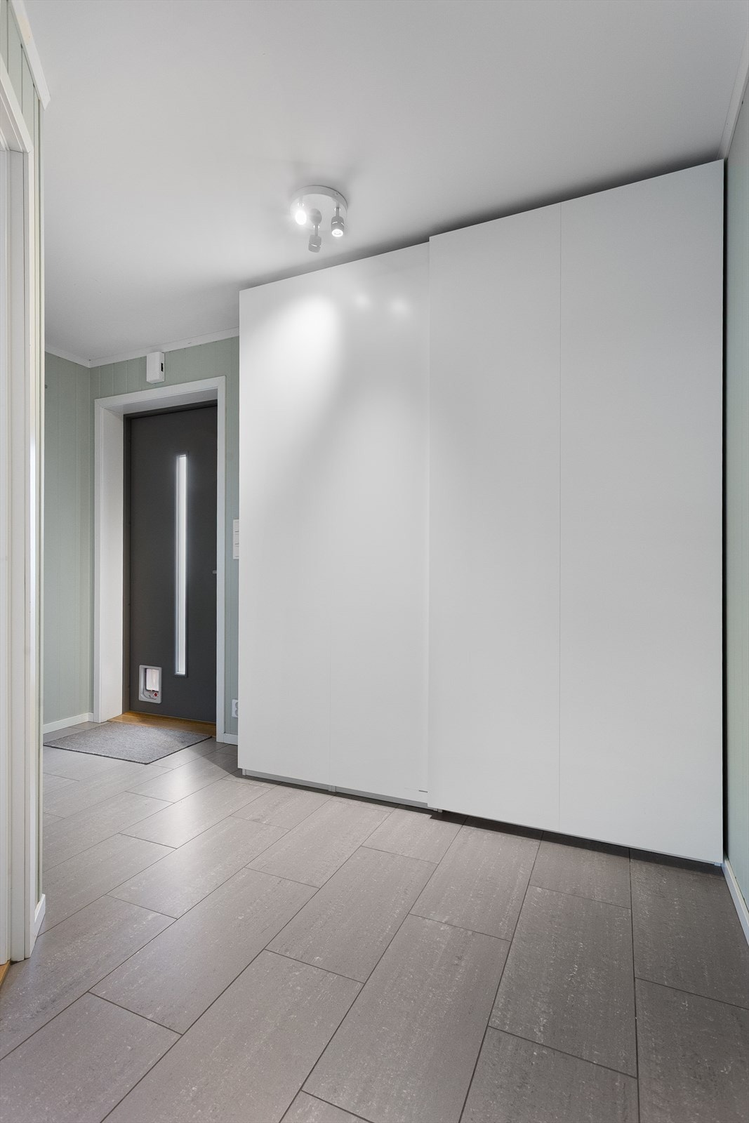 Entré med flislagt gulv med varme. Praktisk oppbevaringsplass i skyvedørsgarderobe. Galleribilde
