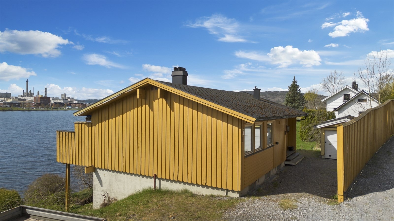 Gruset oppkjørsel med frittstående, enkel garasje og adkomst inn i boligen Galleribilde